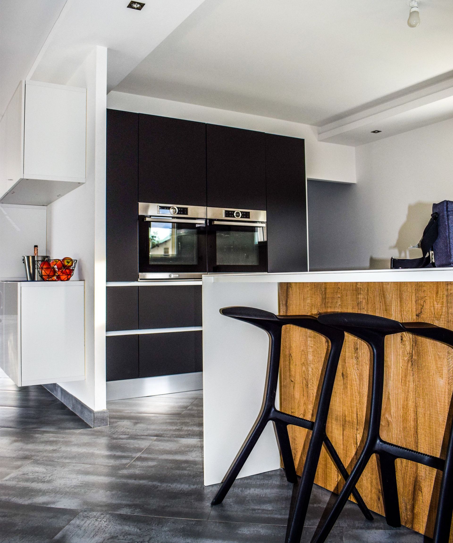 A kitchen with black stools and a wooden counter