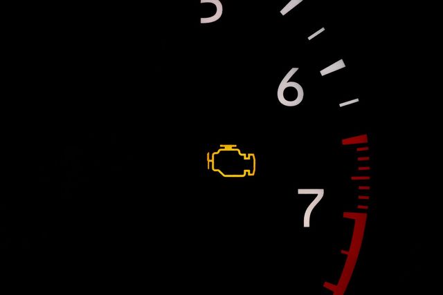 Yellow check engine light on a car dashboard near the 6 and 7 RPM marks with redline visible