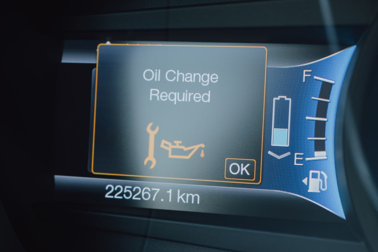 Car dashboard display showing “Oil Change Required,” mileage 225267.1 km, with fuel gauge and warning icon.