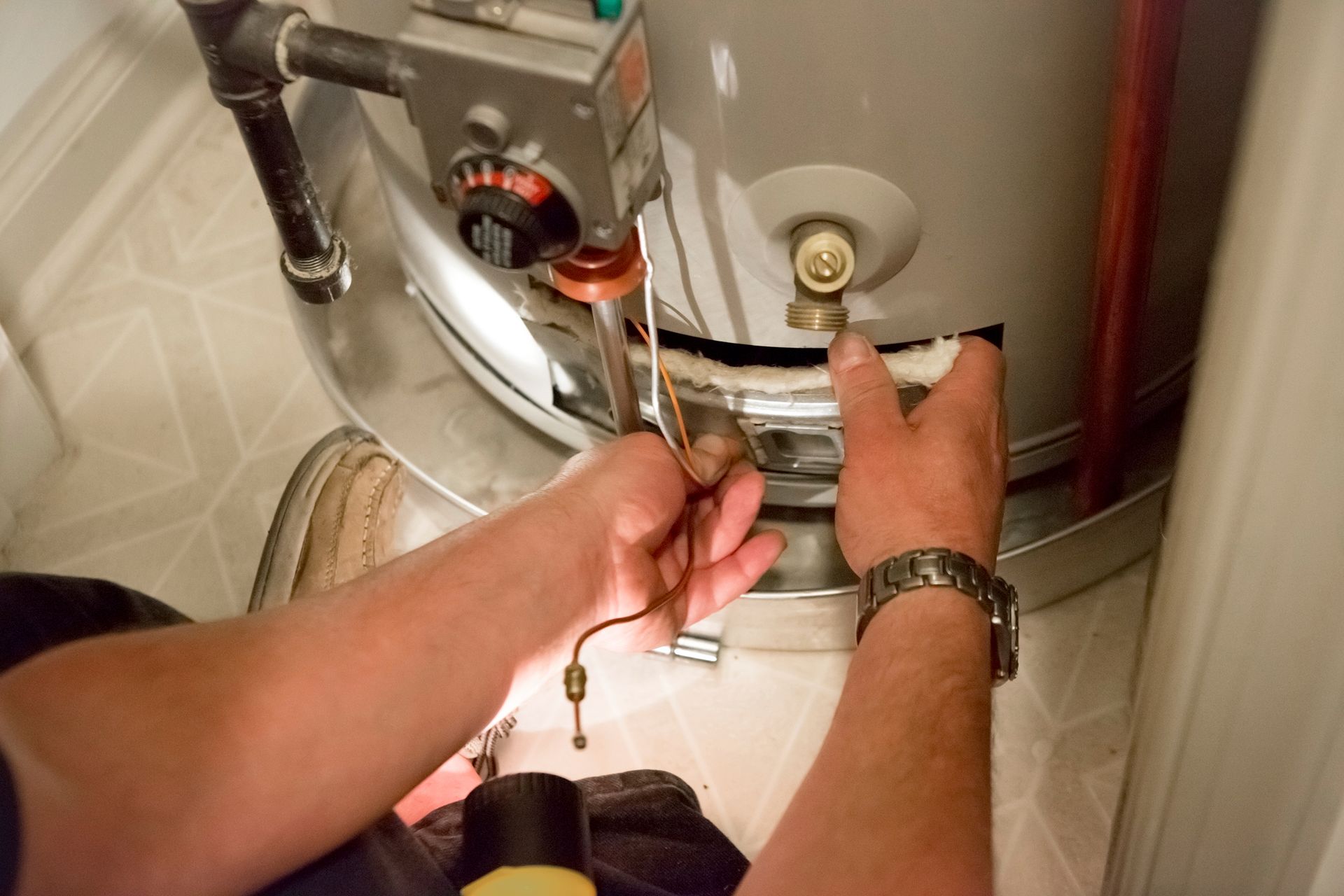 A room with a boiler and a water heater in it.