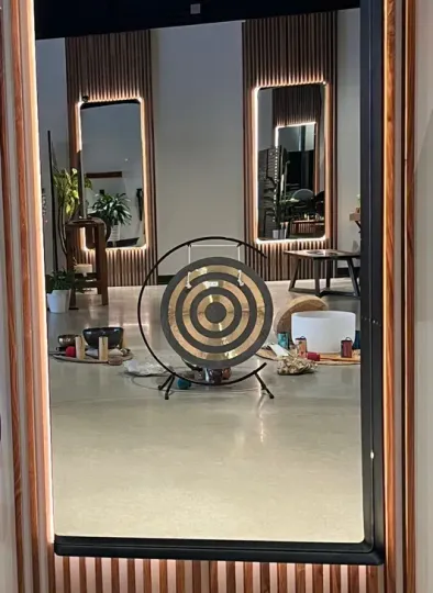 Target practice setup with concentric ring target on a stand in an indoor room with mirrors