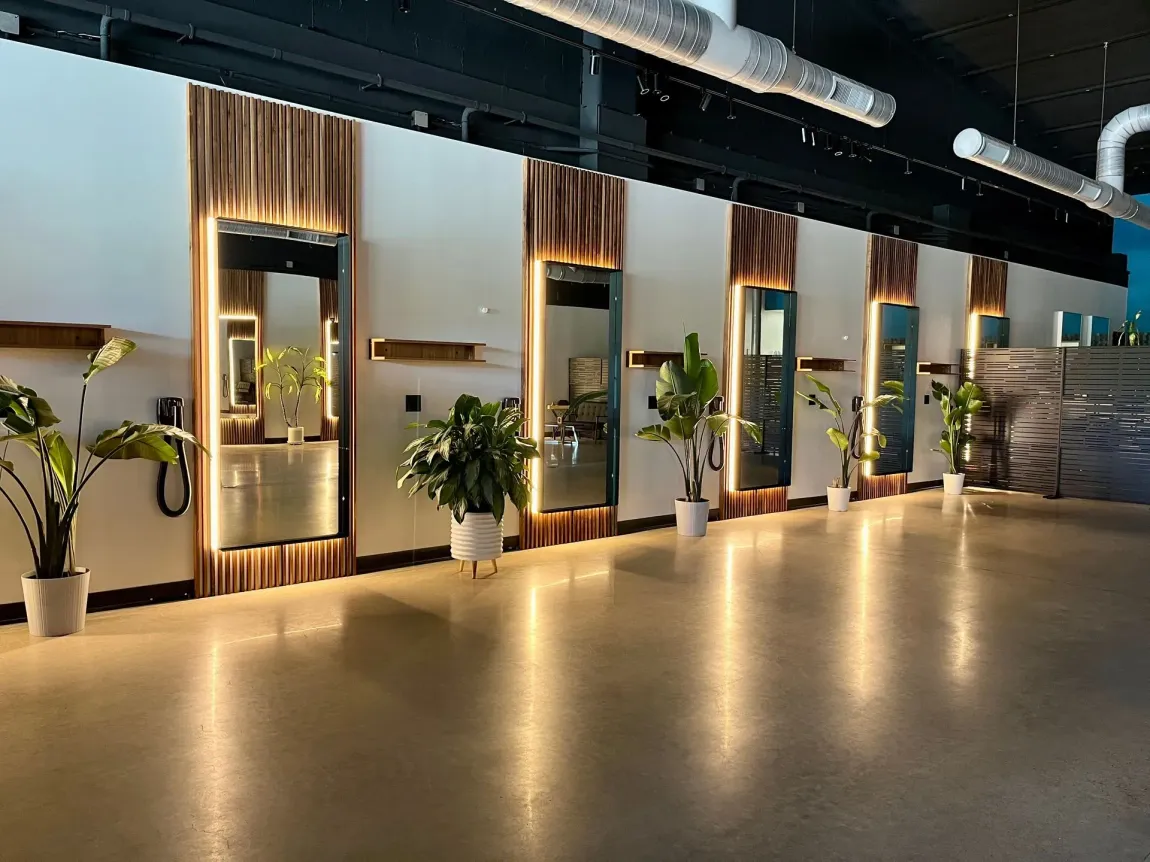Modern lobby with polished floor, decorative plants, and illuminated wall panels