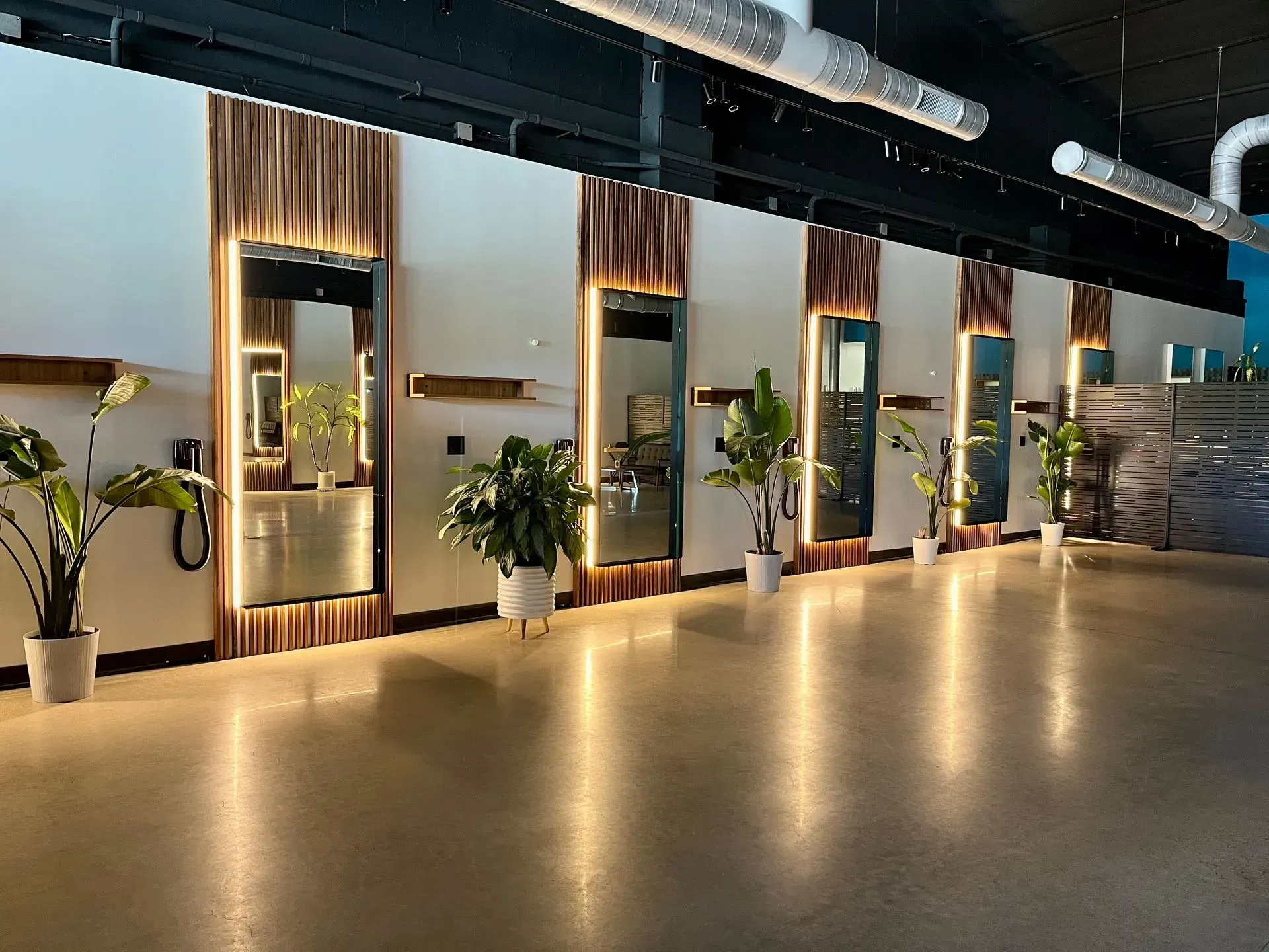 Modern lobby with polished floor, decorative plants, and illuminated wall panels