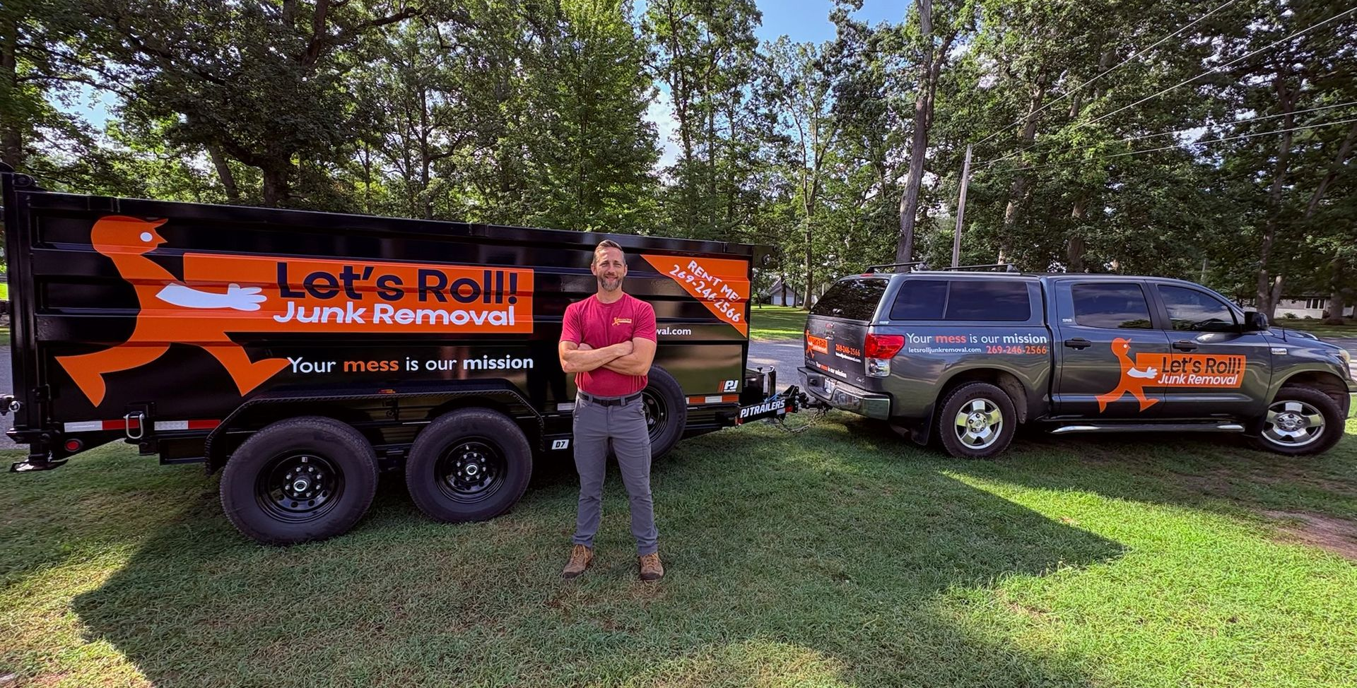 A man is standing in front of a dumpster that says let 's roll.