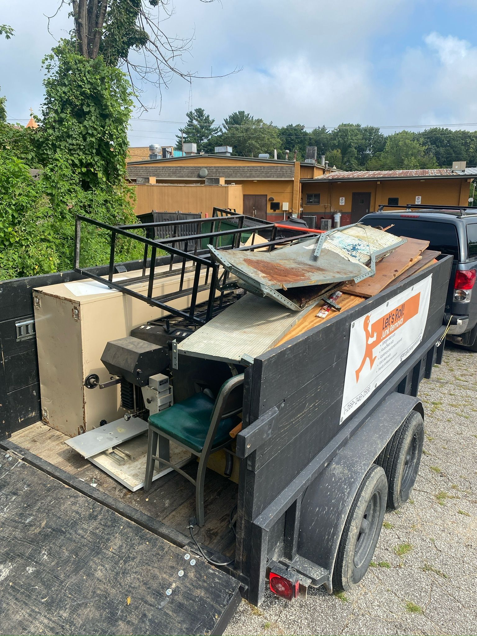 A trailer full of junk is parked in front of a building