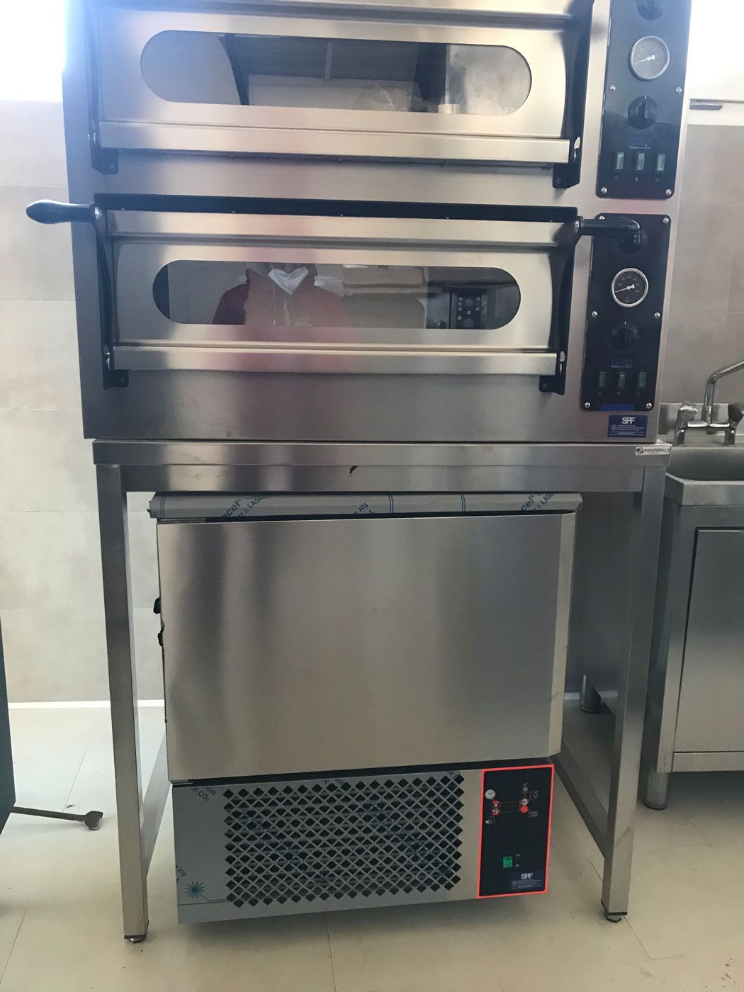 Forno professionale in acciaio inox per cucina, con pannelli di controllo e base ventilata.