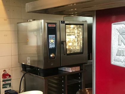 Forno professionale in acciaio inox per cucina, con interno illuminato e pannello di controllo digitale.