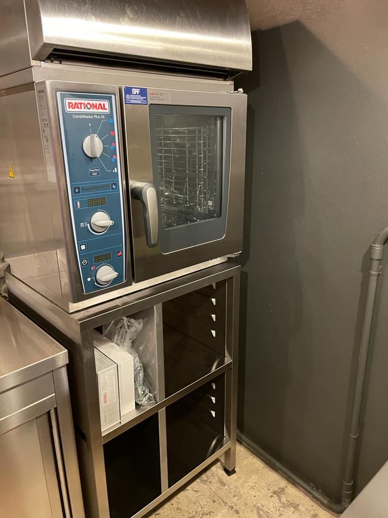 Forno professionale in acciaio inox su ripiano metallico in cucina o in zona di preparazione degli alimenti.