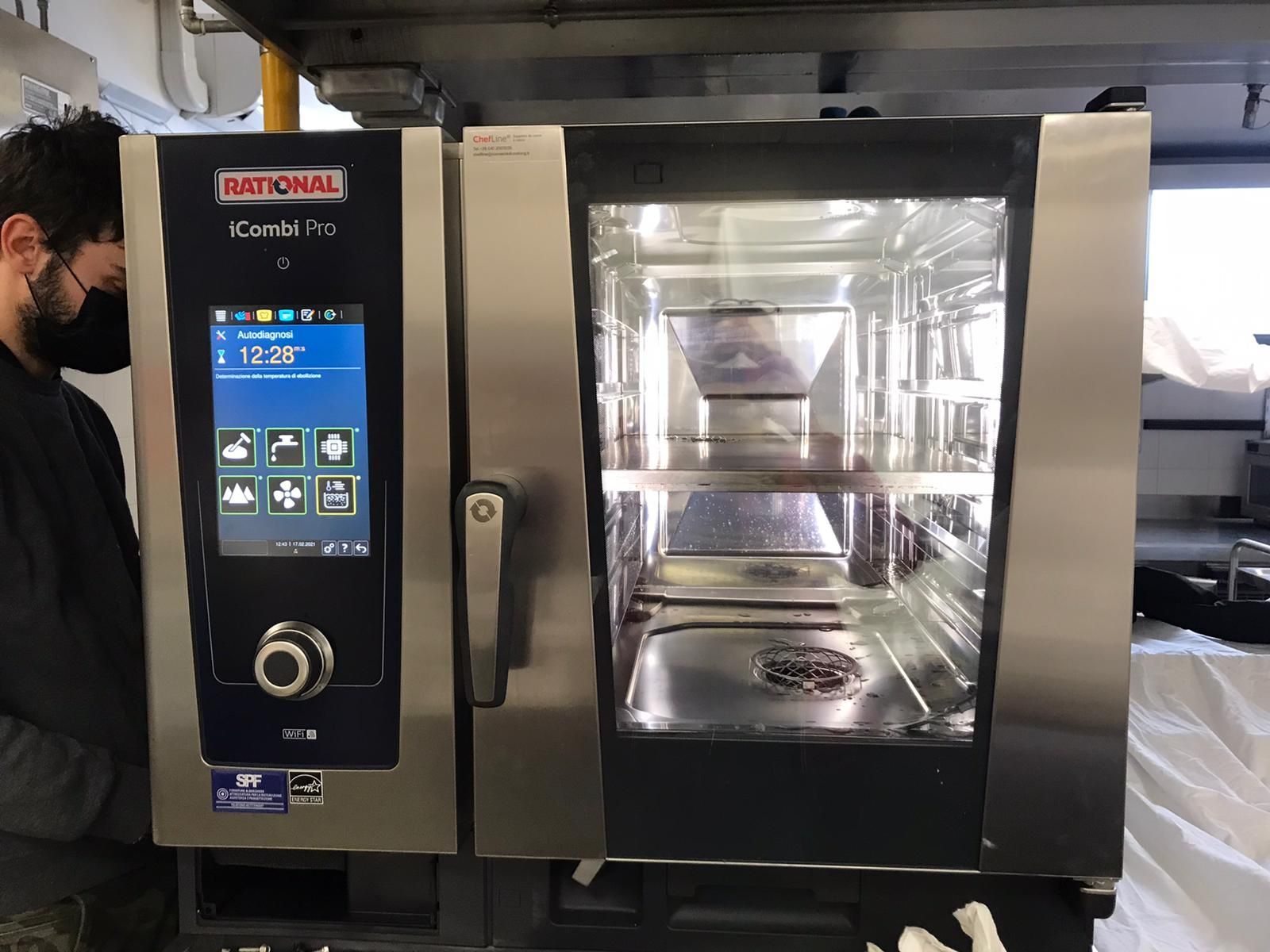 Forno professionale in acciaio inox con pannello di controllo touchscreen e porta in vetro, installato in una cucina.