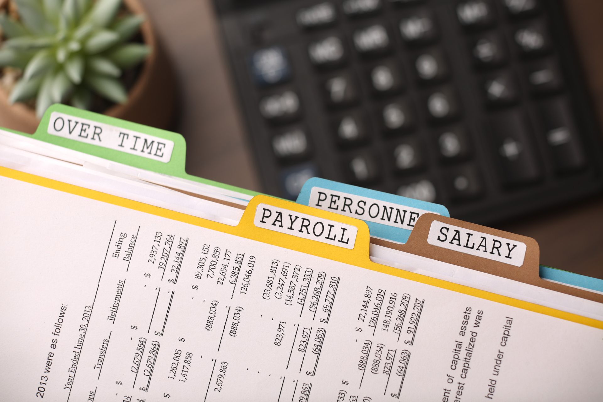 Overtime, Payroll, Personnel, and Salary file folders with a calculator and plant.