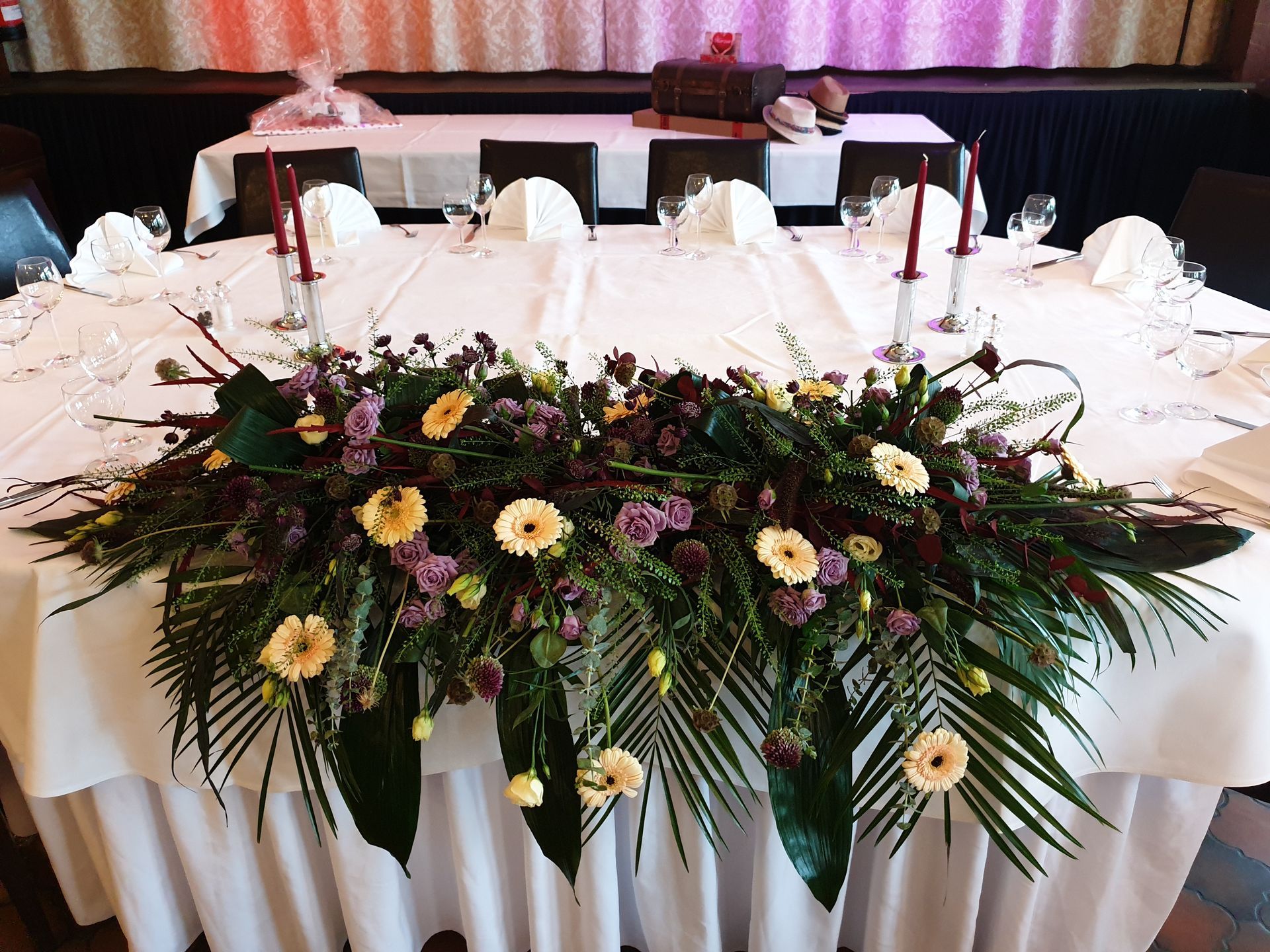 Ein langer Tisch mit Blumen und Kerzen darauf