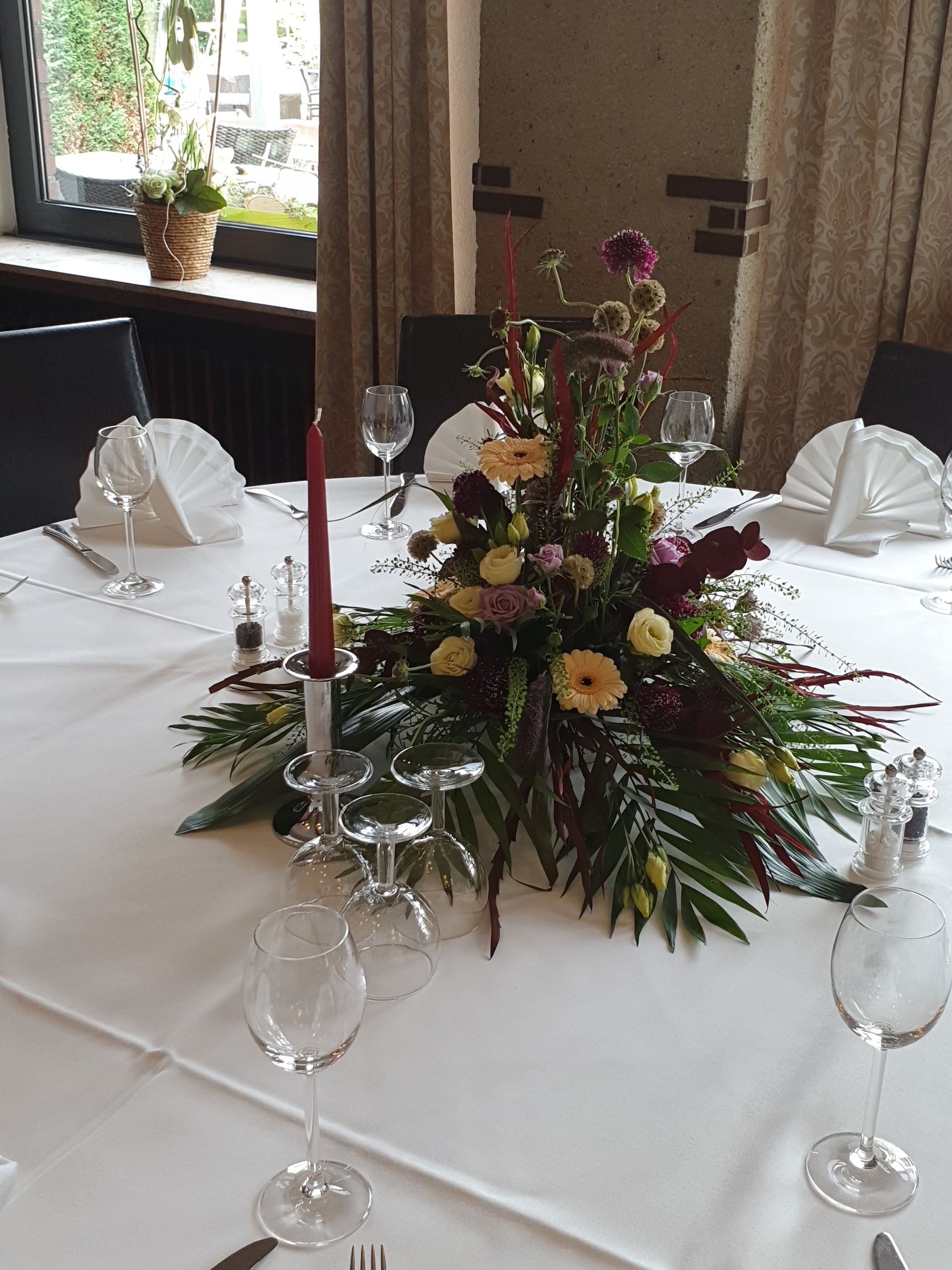 Ein Tisch mit Blumen und Kerzen darauf