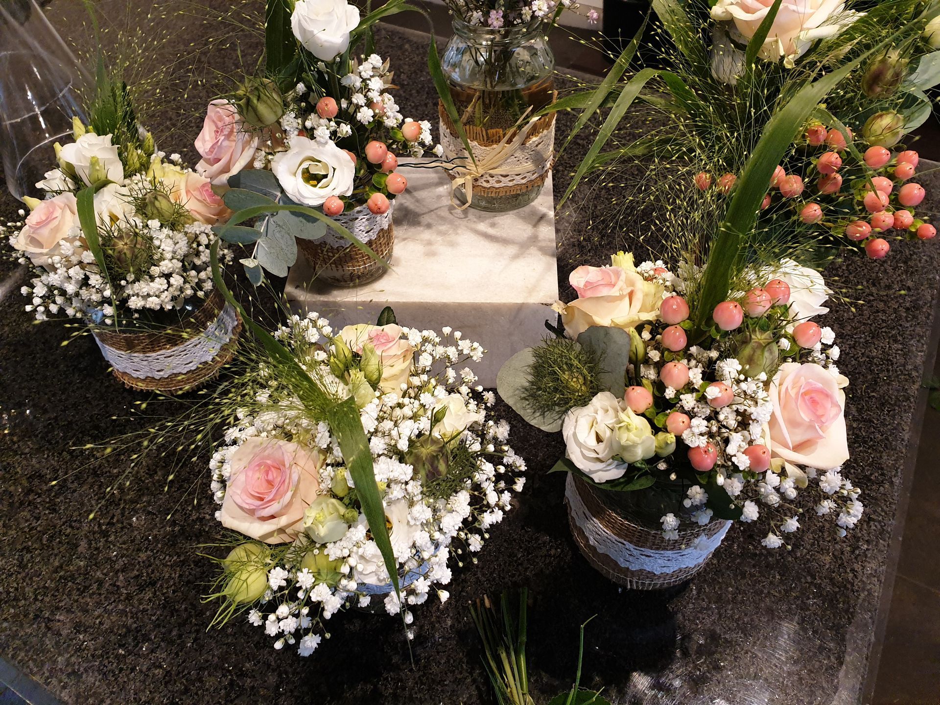 Auf einem Tisch stehen mehrere Vasen voller Blumen.