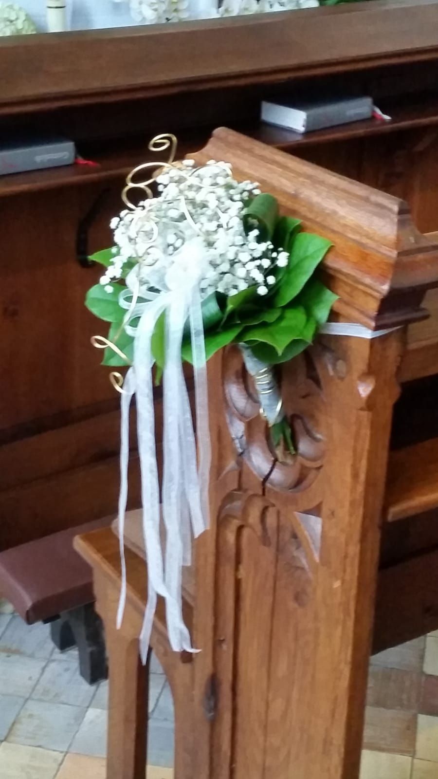 Eine Holzbank mit Blumen und Bändern darauf