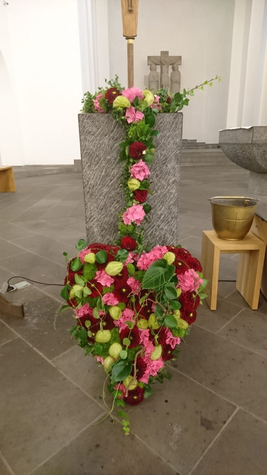 Ein herzförmiges Blumenarrangement in einer Kirche.