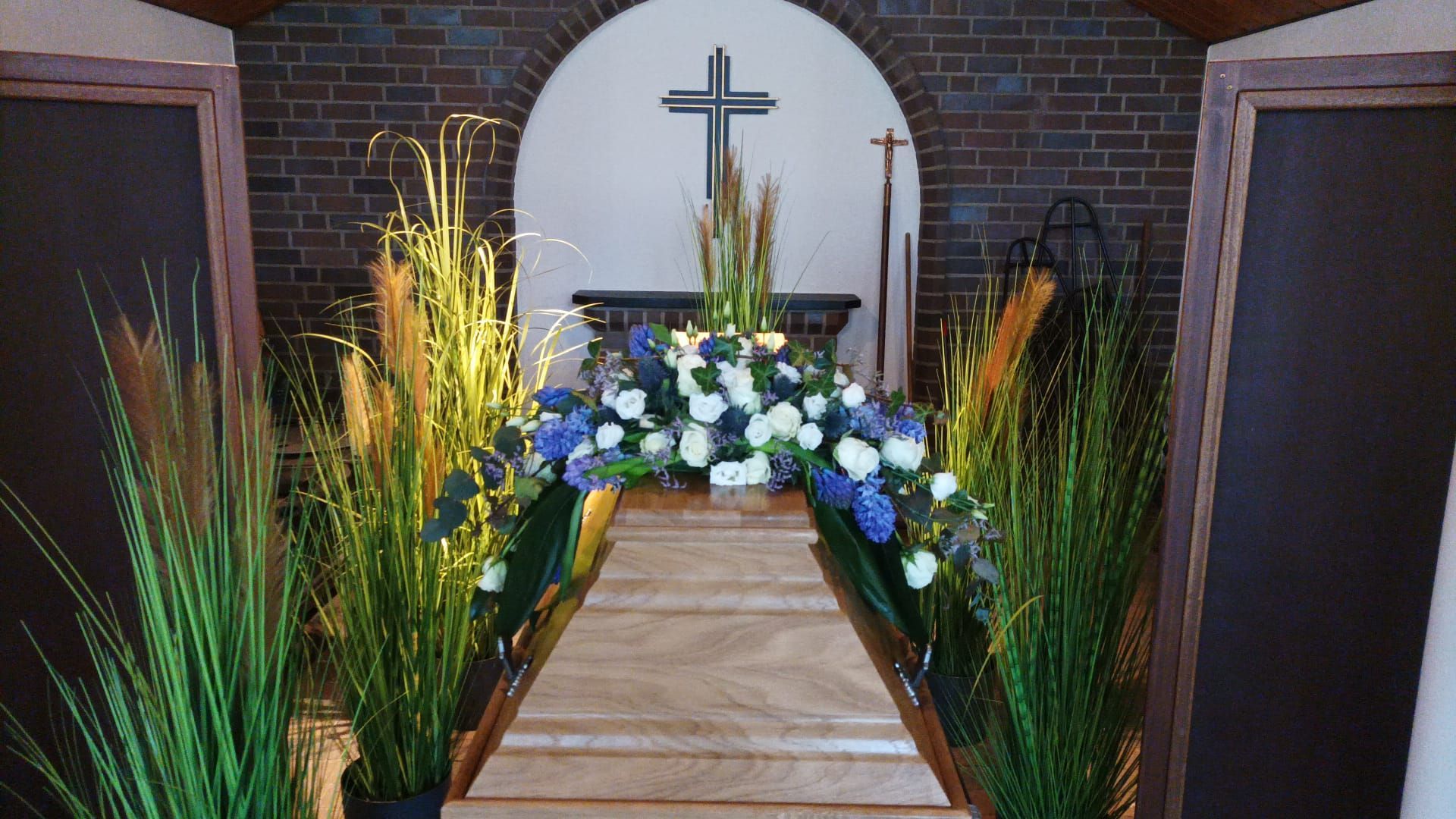 Eine Kirche mit Blumen und einem Kreuz an der Wand.