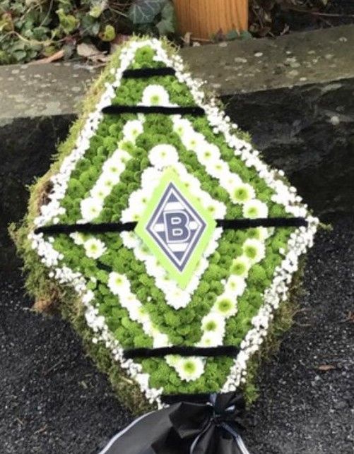 Ein grün-weißes Blumenarrangement mit dem Buchstaben B darauf
