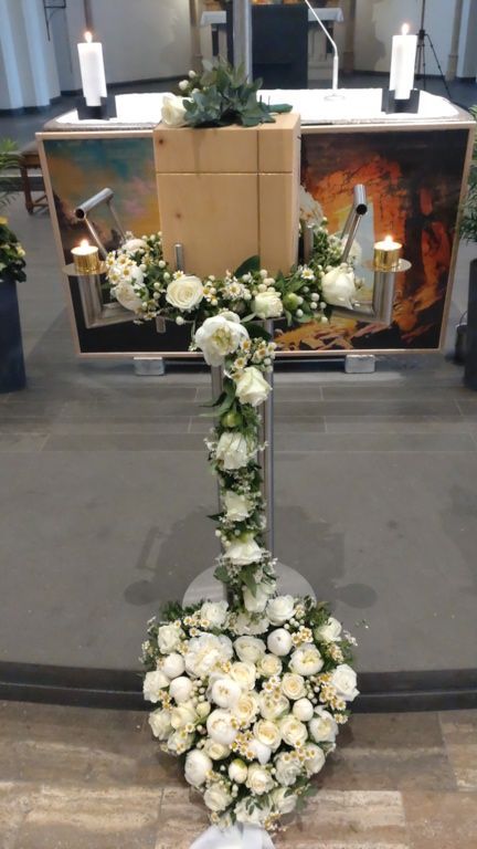 Ein mit weißen Blumen und Kerzen geschmückter Kirchenaltar.