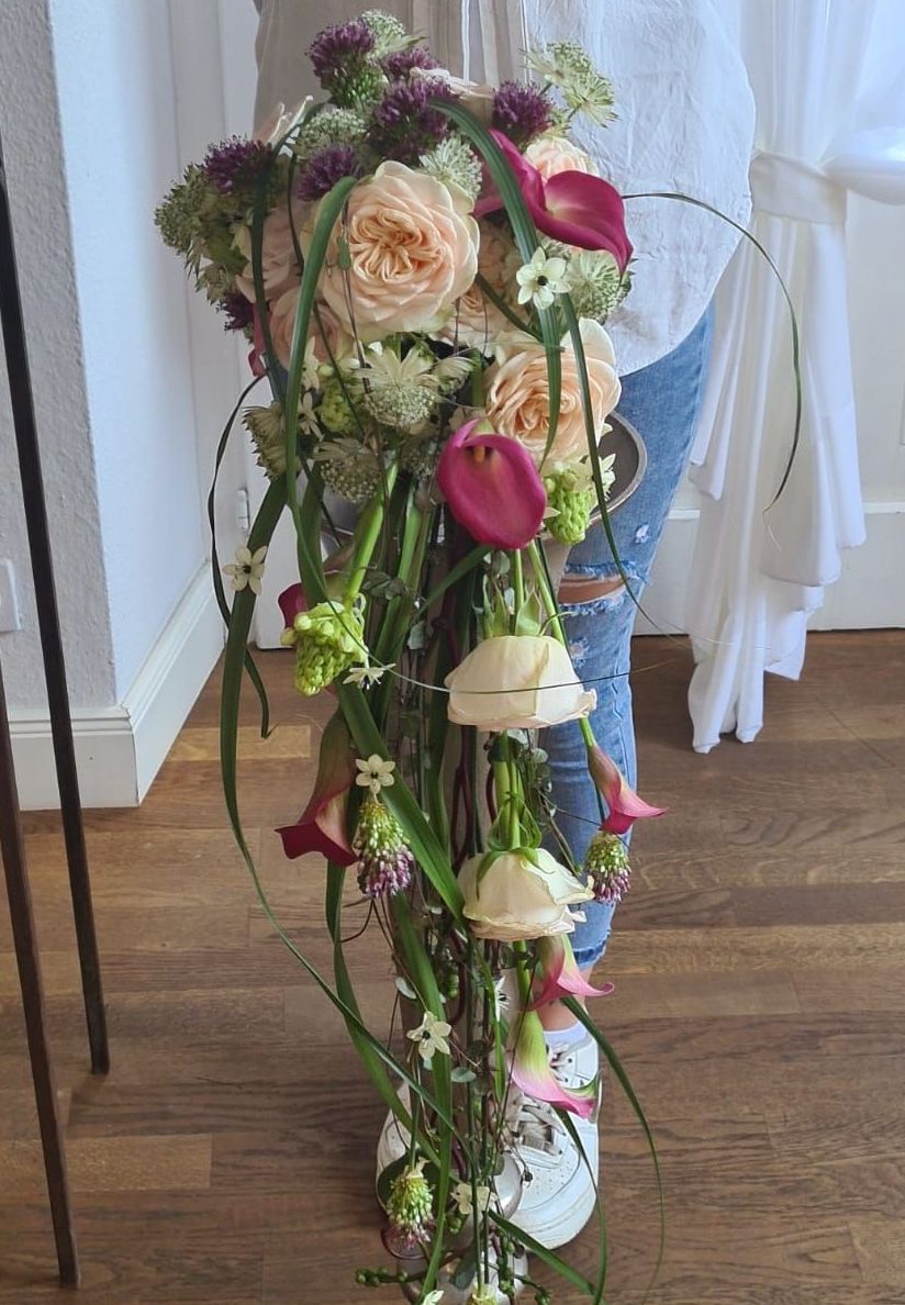 Eine Frau hält einen Blumenstrauß in einer Vase.