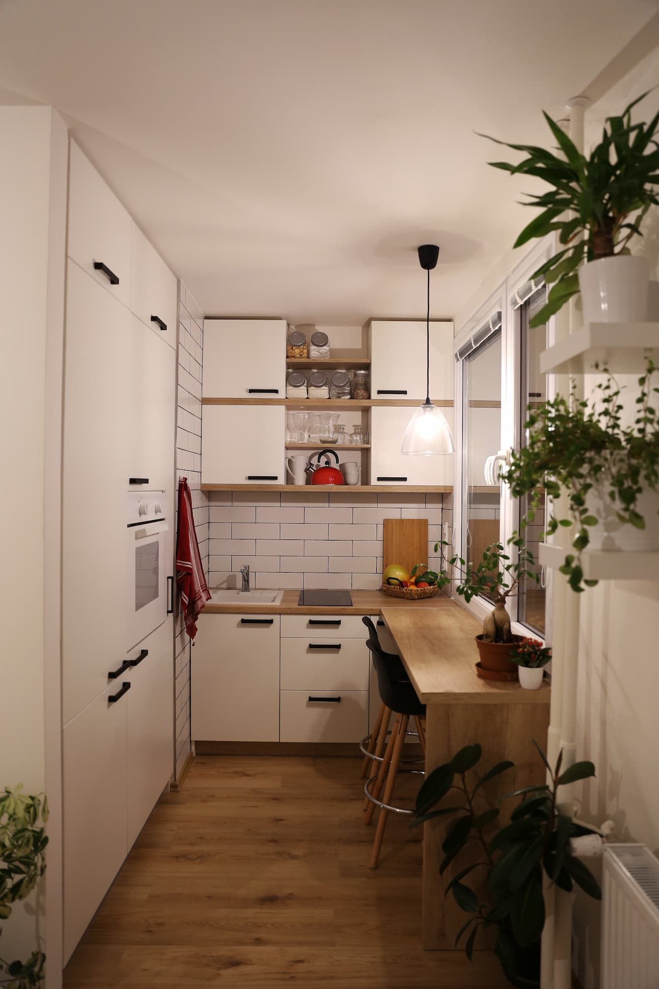 Narrow White Kitchen With Wood Counters and Cabinets, With Bar Seating and Plants — McCormick Upholstery In Coolum Beach, QLD