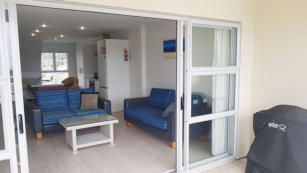 A living room with a couch , table , and sliding glass doors.