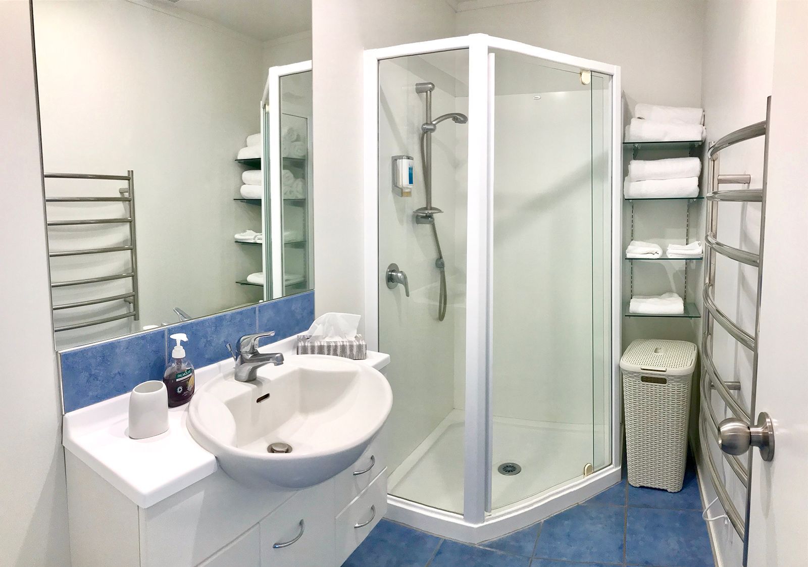 A bathroom with a sink , mirror and shower.