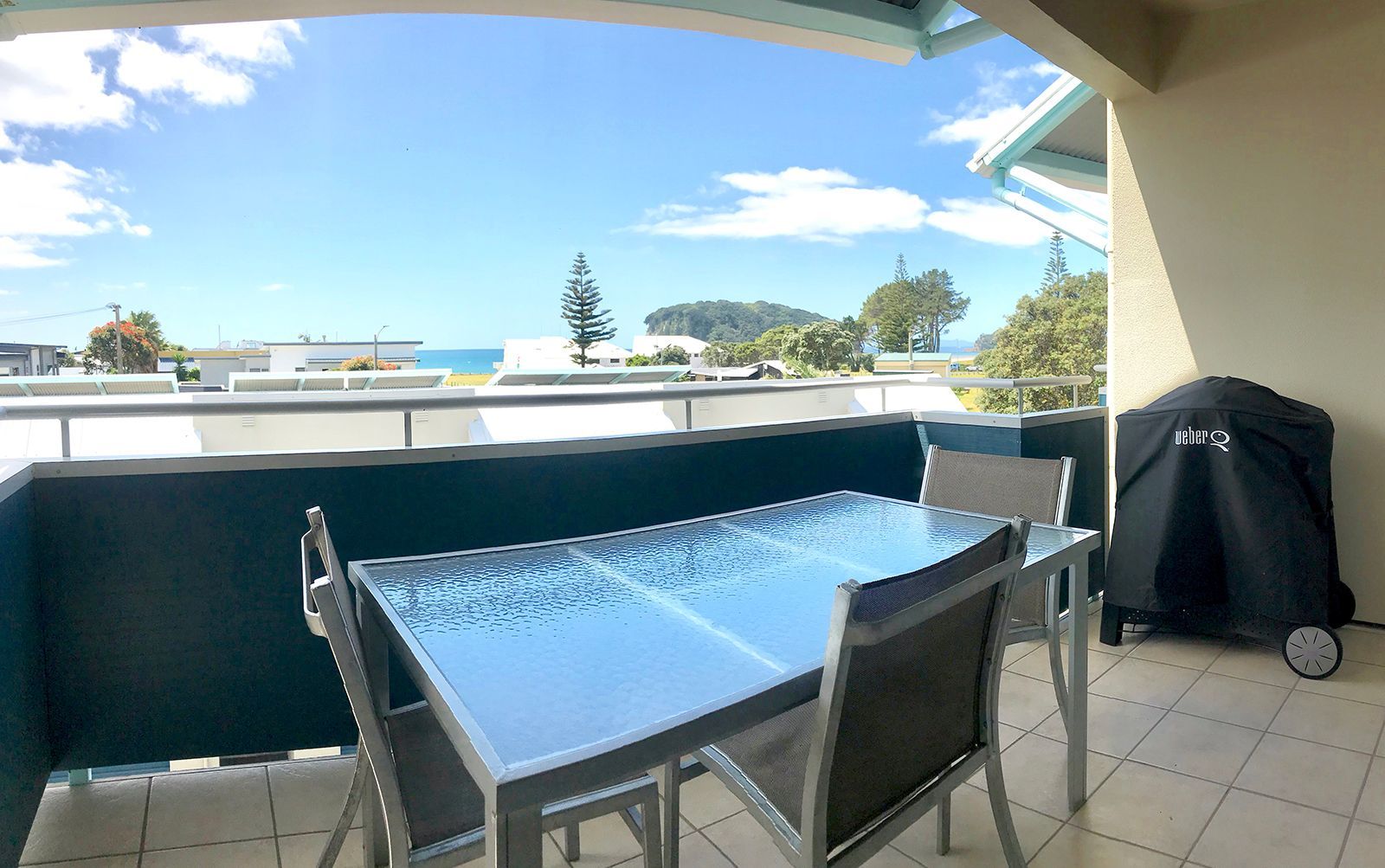 A balcony with a table and chairs with a view of the ocean