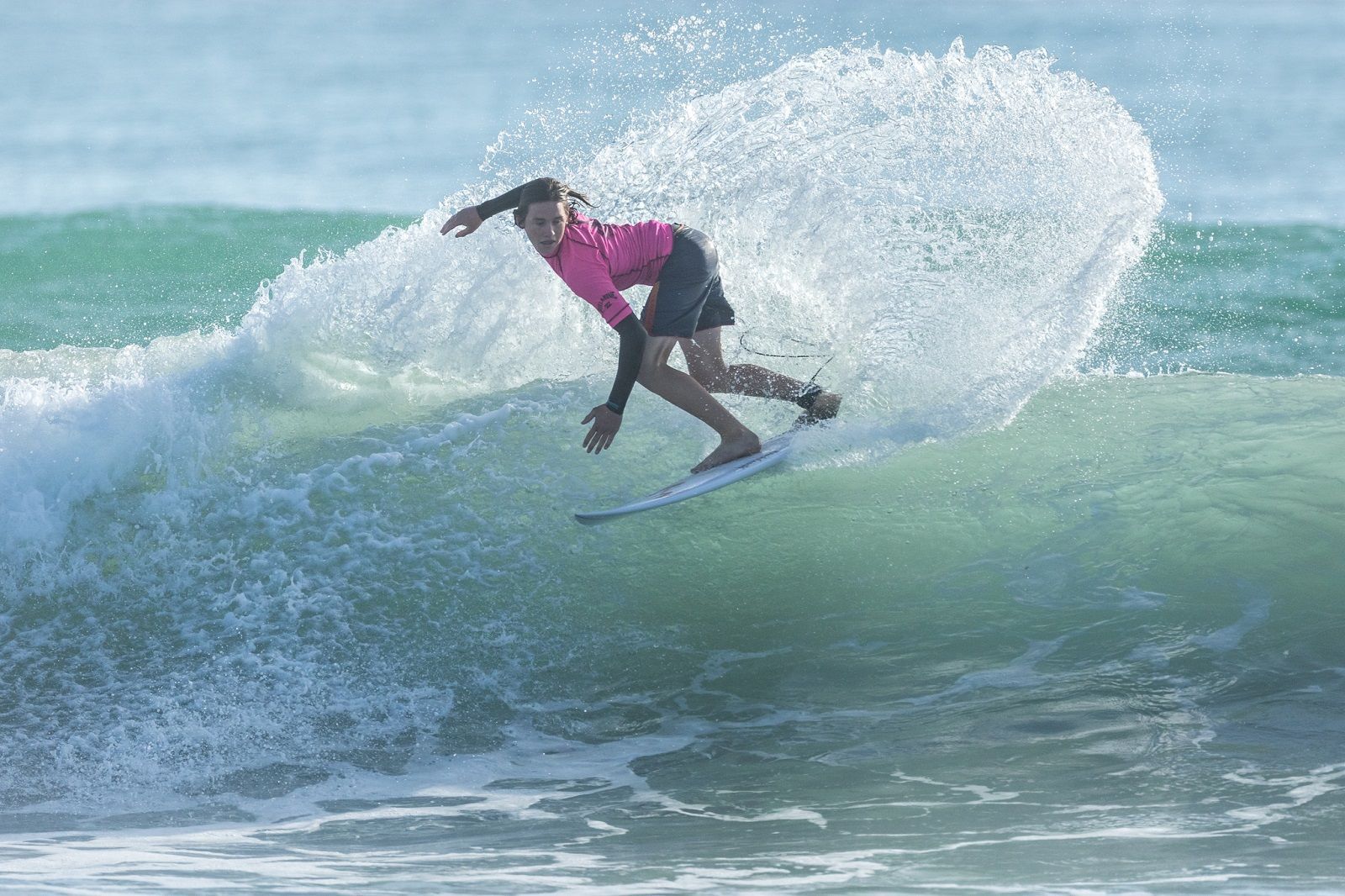 A man is riding a wave on a surfboard in the ocean.