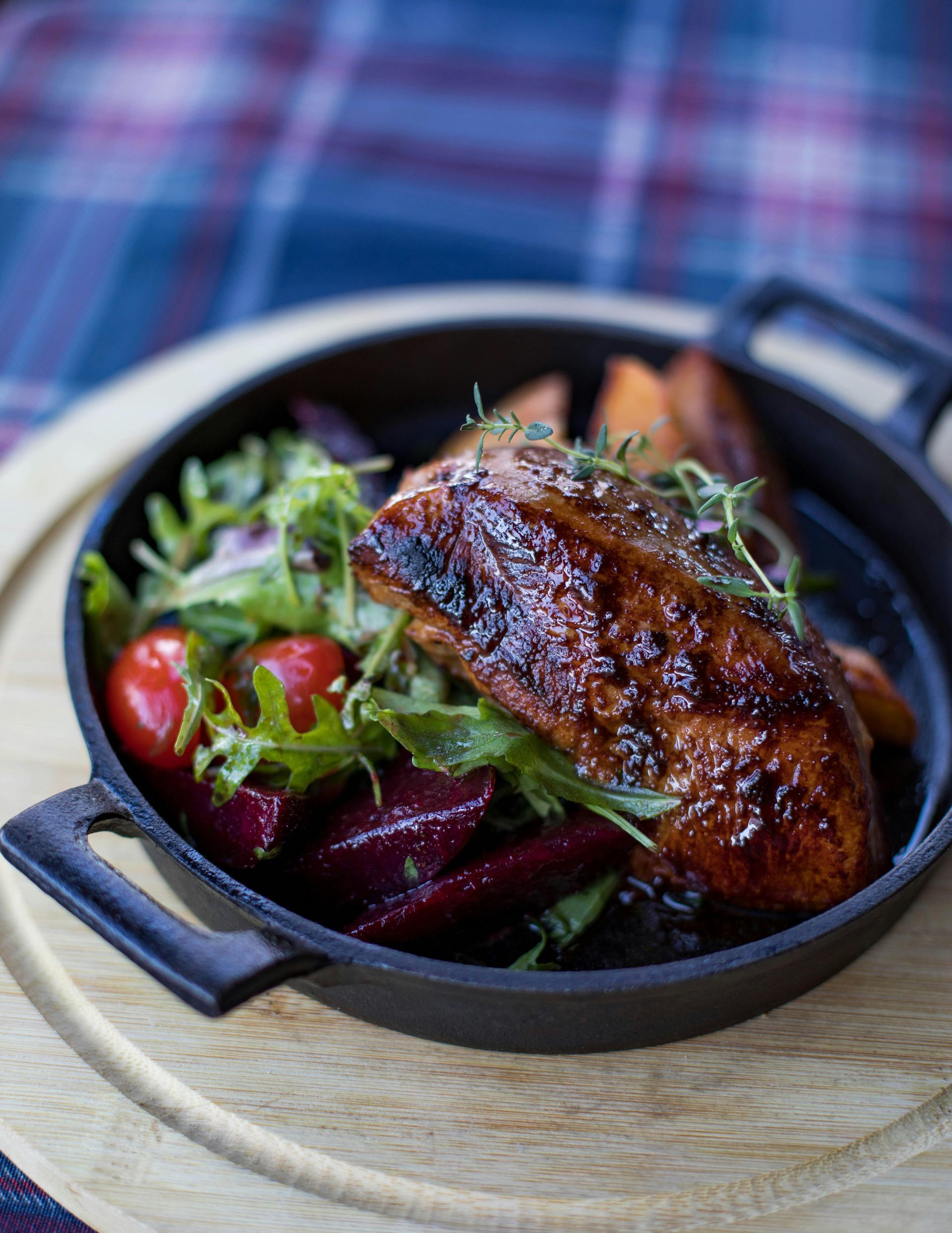A pan filled with meat and vegetables on a wooden table.