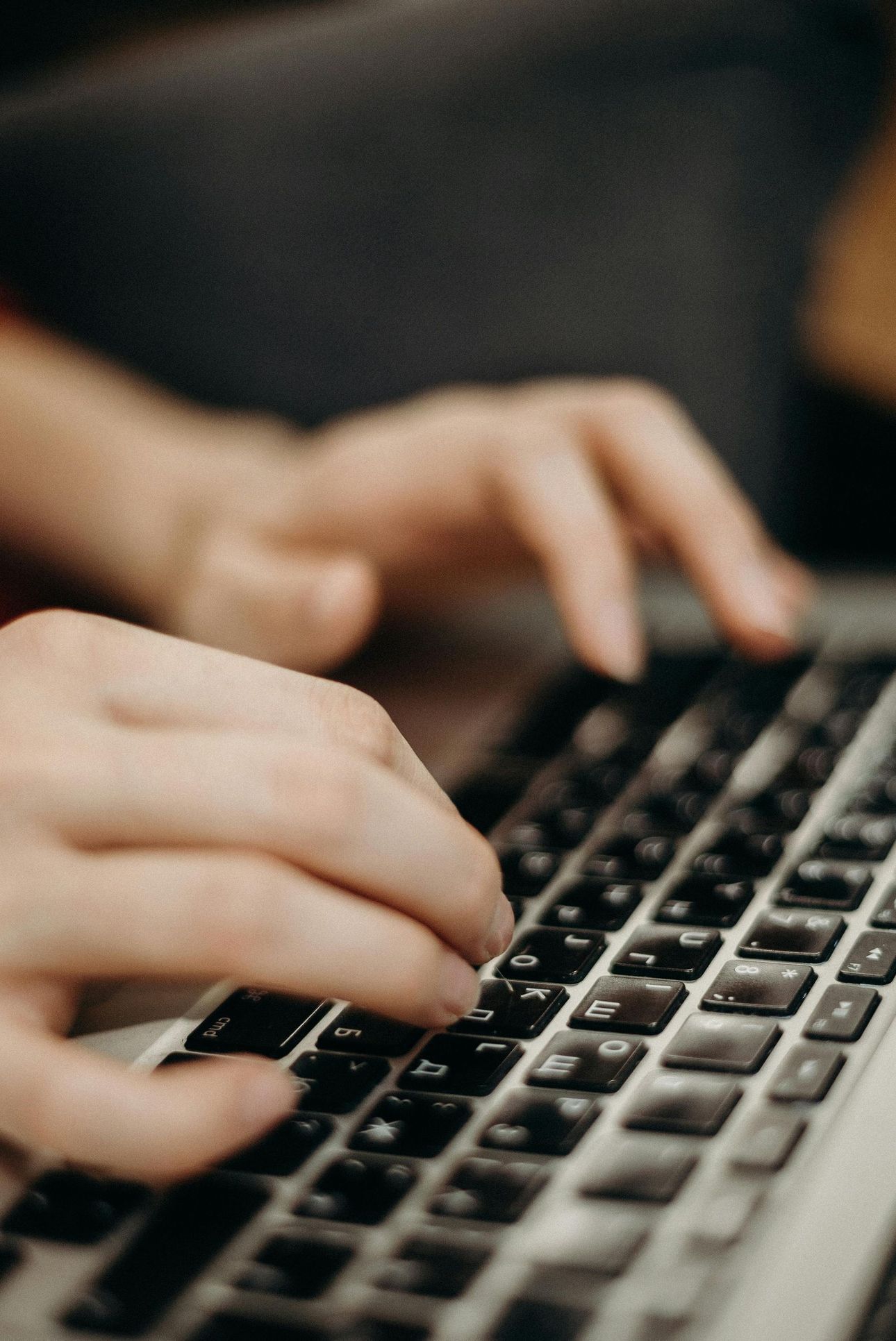 A person is typing on a laptop keyboard.