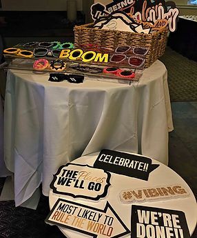 Photo booth props on a table: sunglasses, signs with phrases like 
