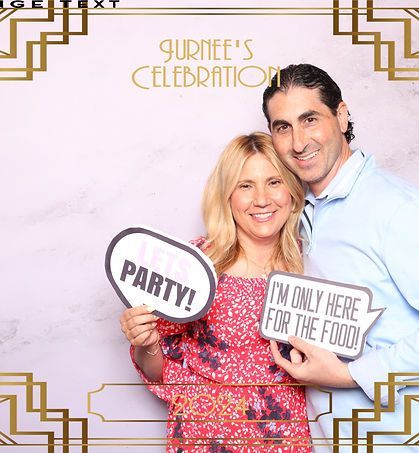 Couple in a photo booth holding signs that read 