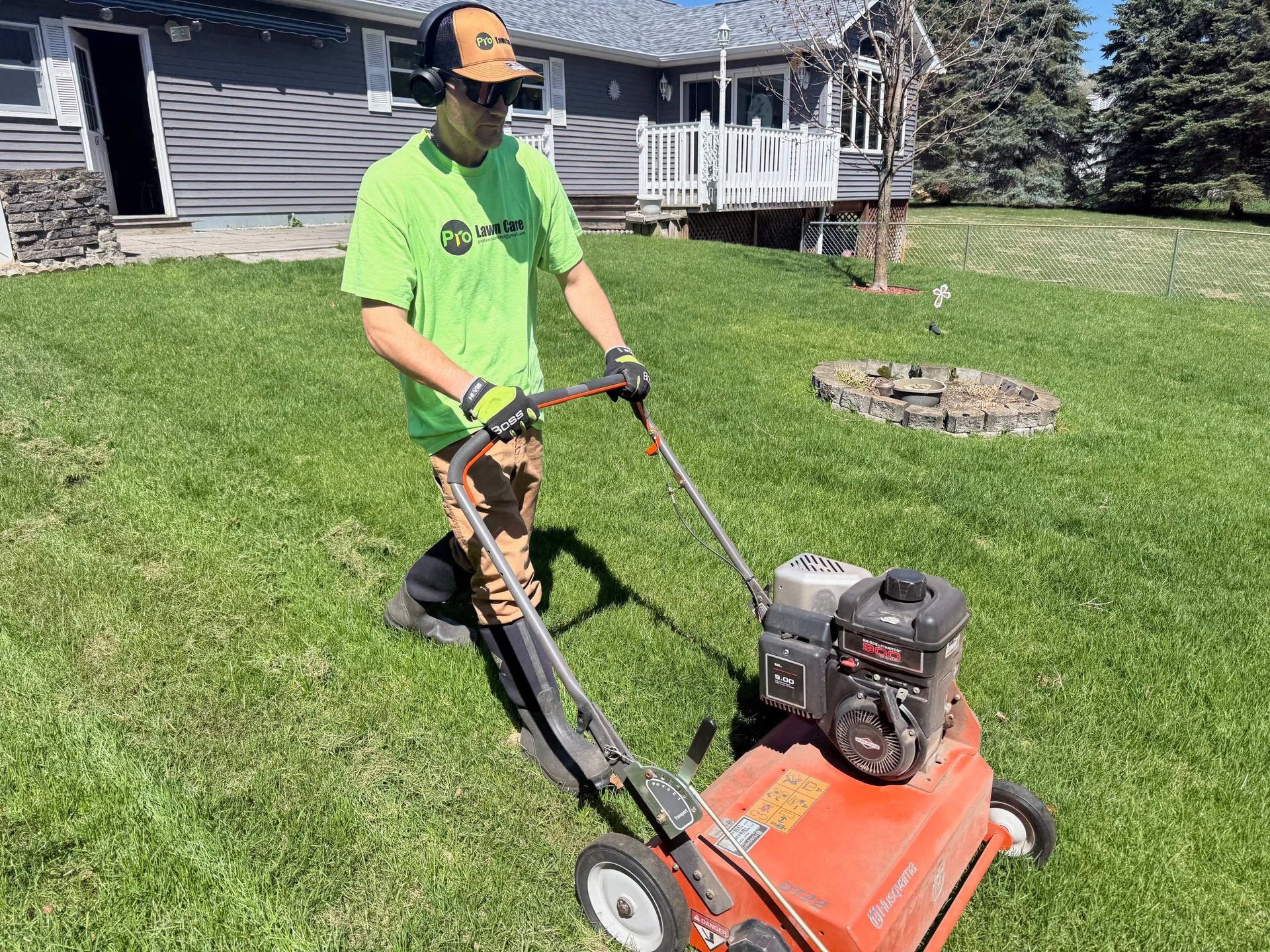 A man is riding a lawn mower on a lush green lawn.