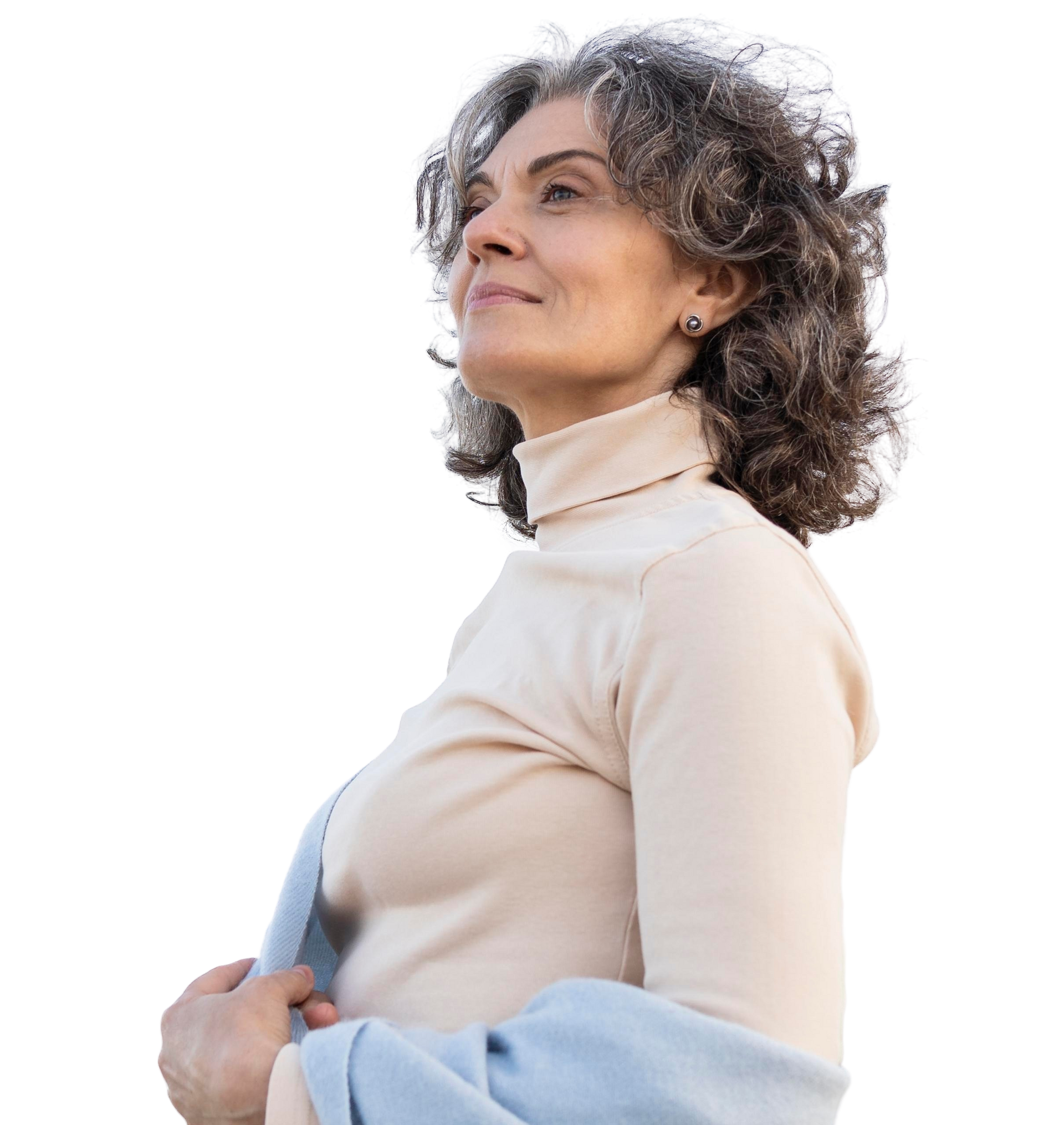 Woman with curly gray hair looks upwards, wearing a cream turtleneck and holding a blue scarf.