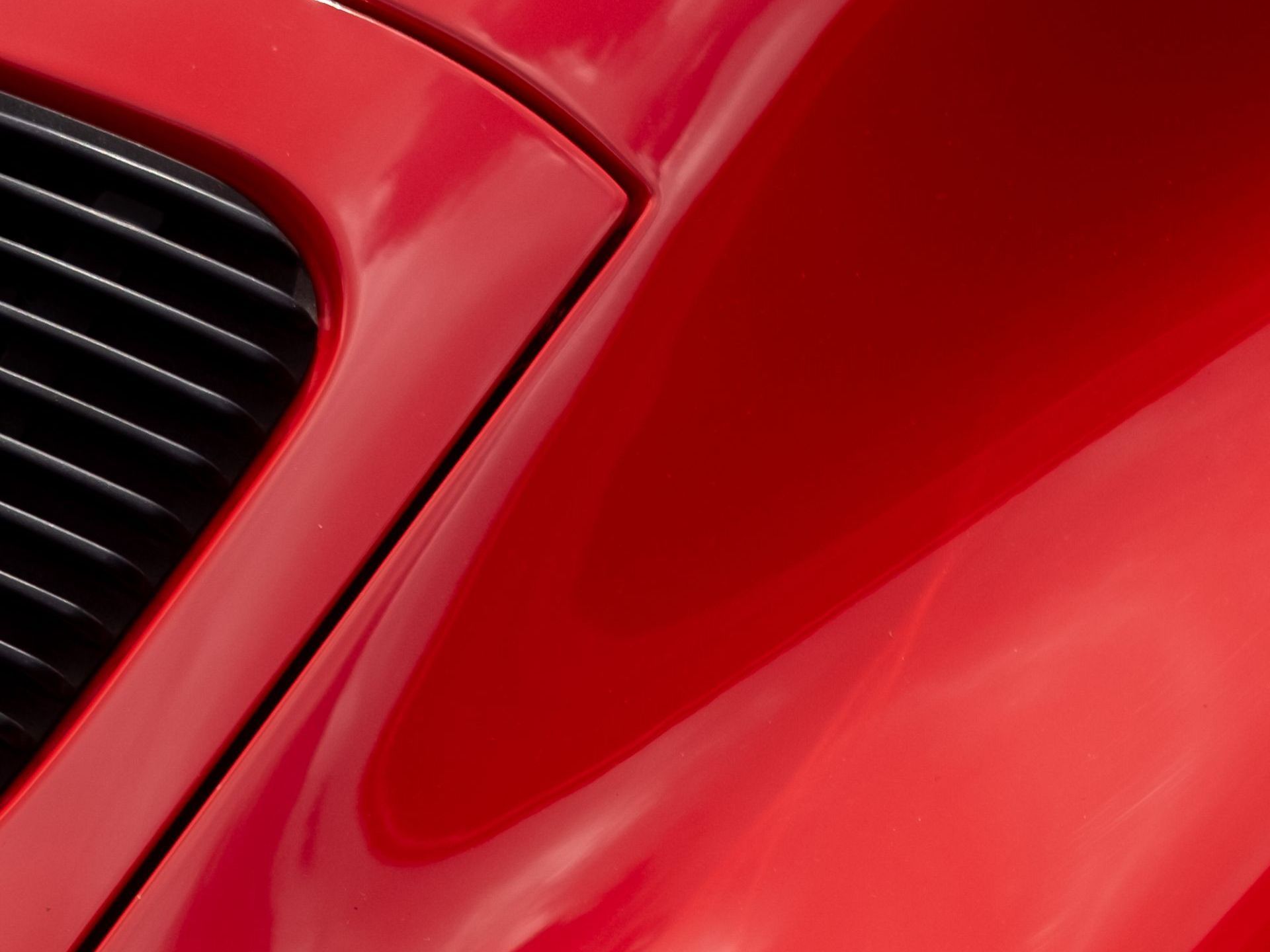 A close up of a red car with a black grille