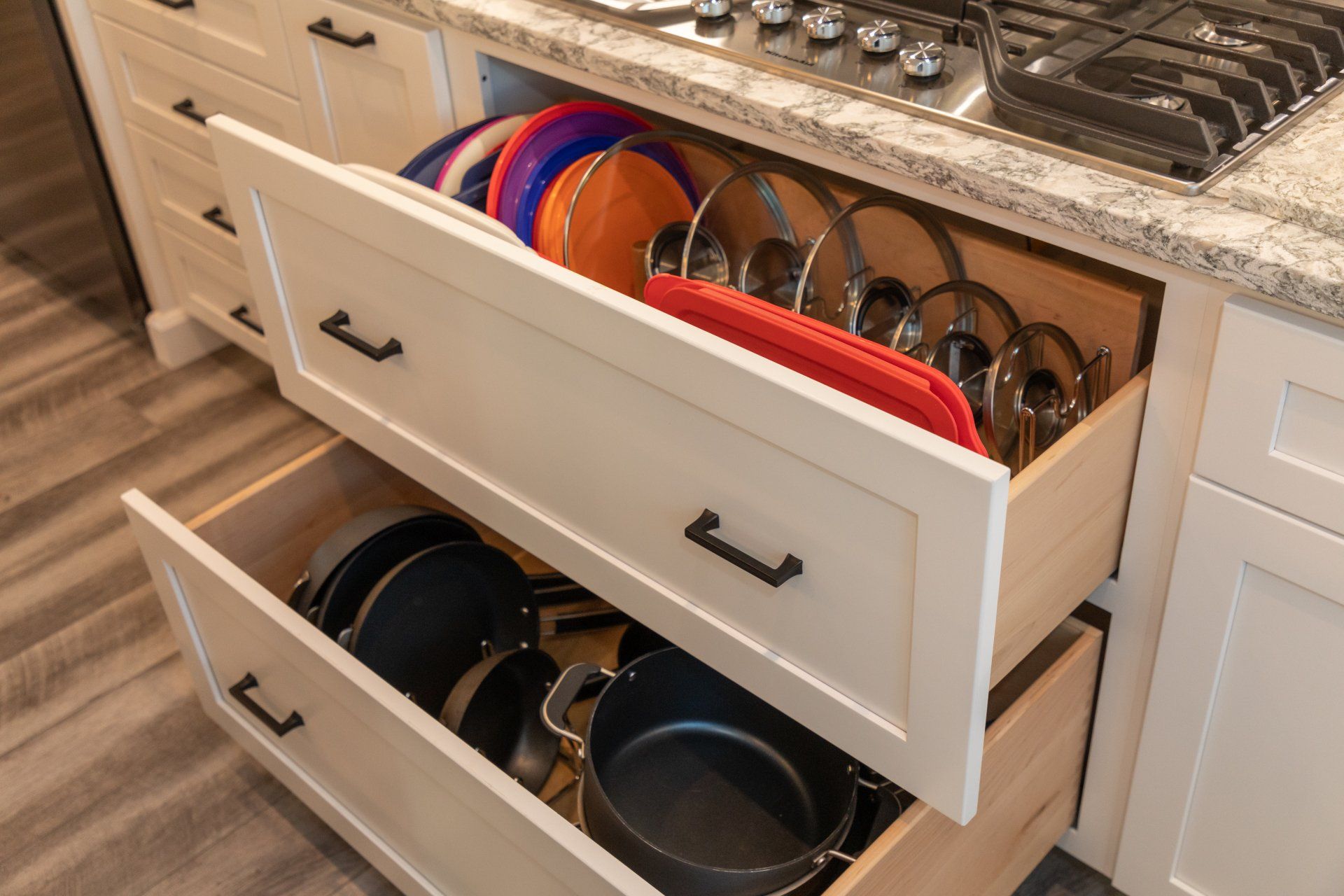 A kitchen drawer filled with pots, pans, and plates.