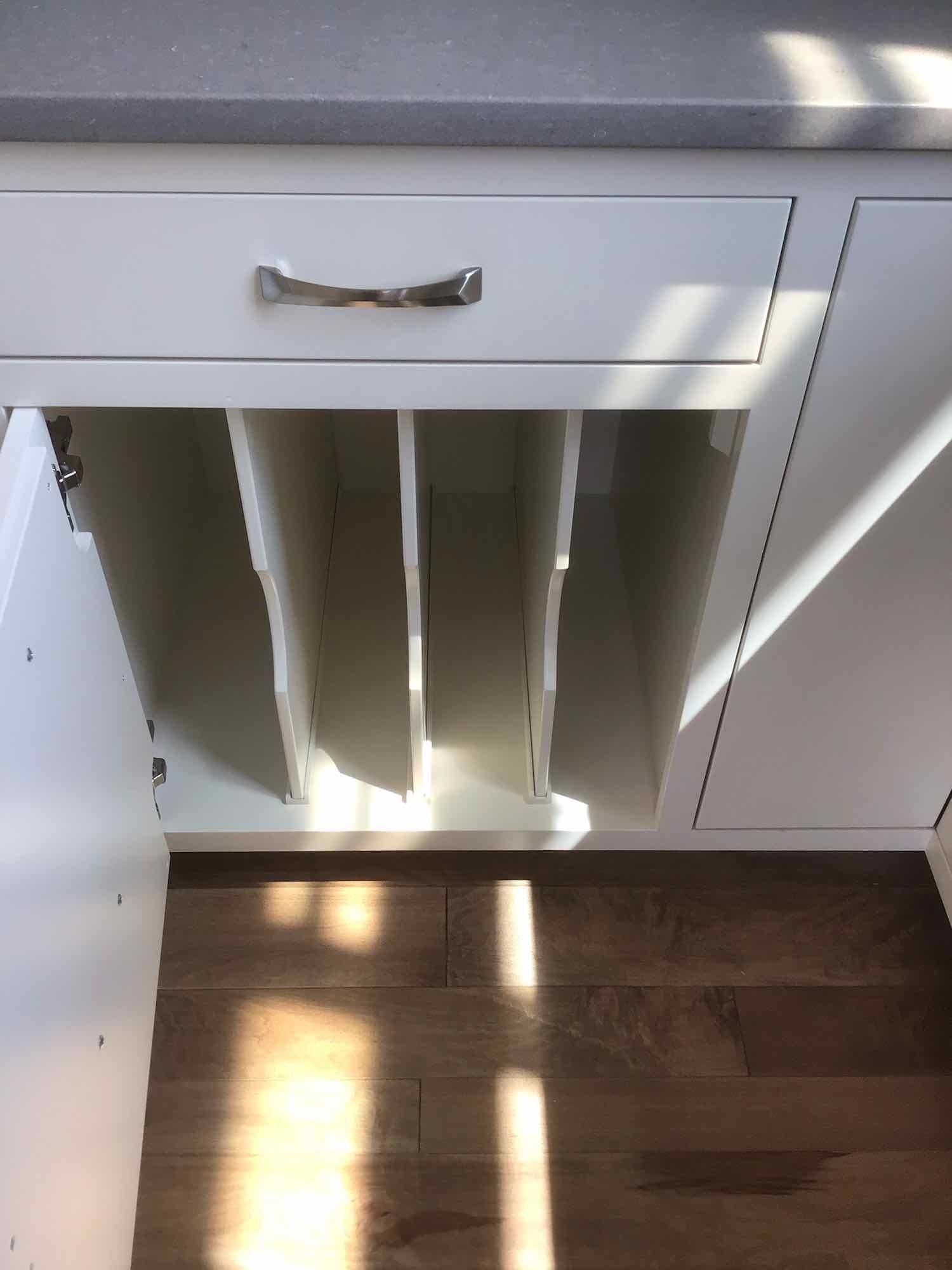 A white cabinet with a drawer underneath it.