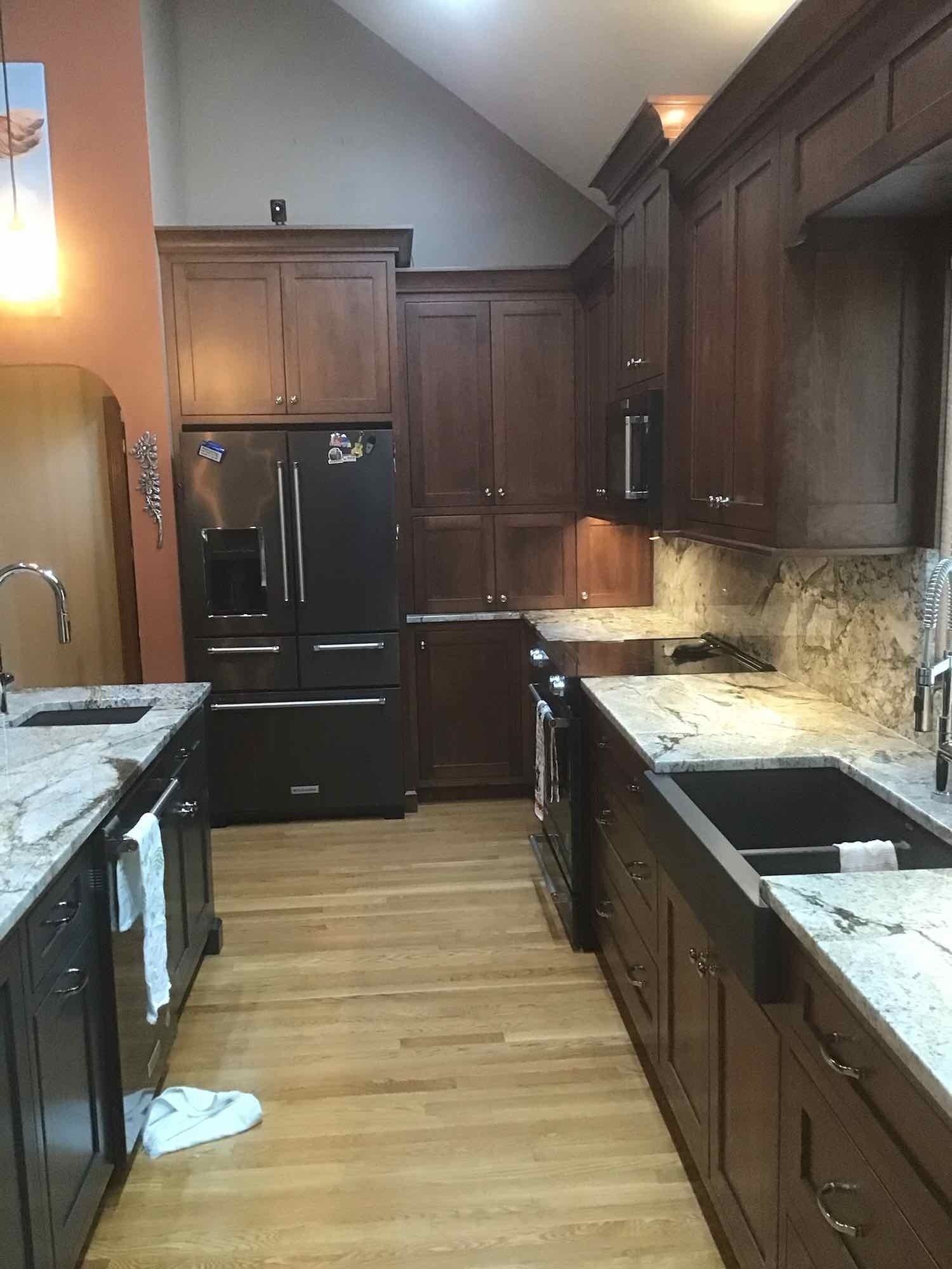 Kitchen with dark wood cabinets, stainless steel appliances, and light countertops.