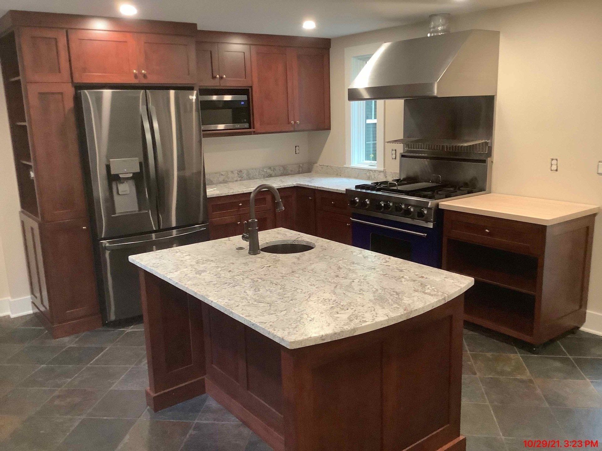 Kitchen with dark wood cabinets, stainless steel appliances, and granite countertops.