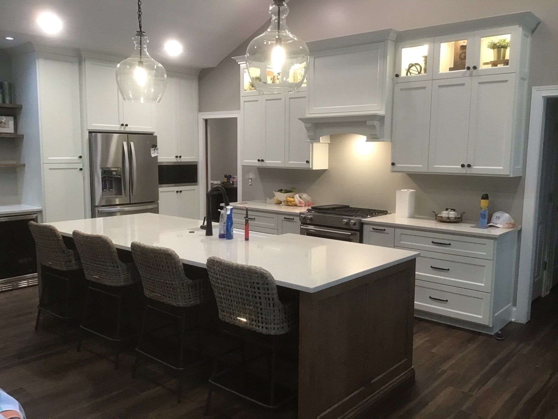 Modern kitchen with large island and light blue cabinetry, stainless steel appliances, and dark wood floors.