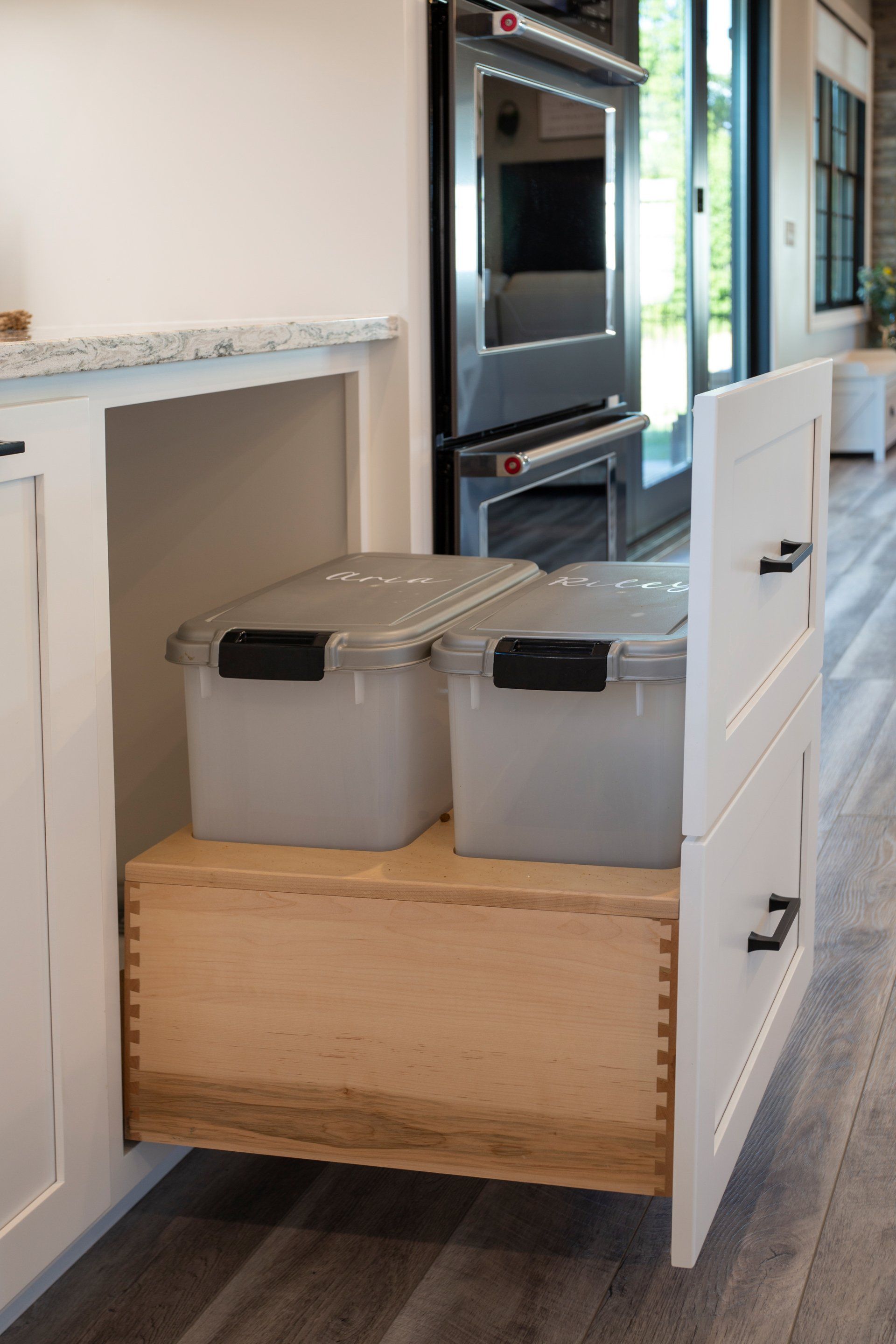 A kitchen drawer with two plastic containers in it.