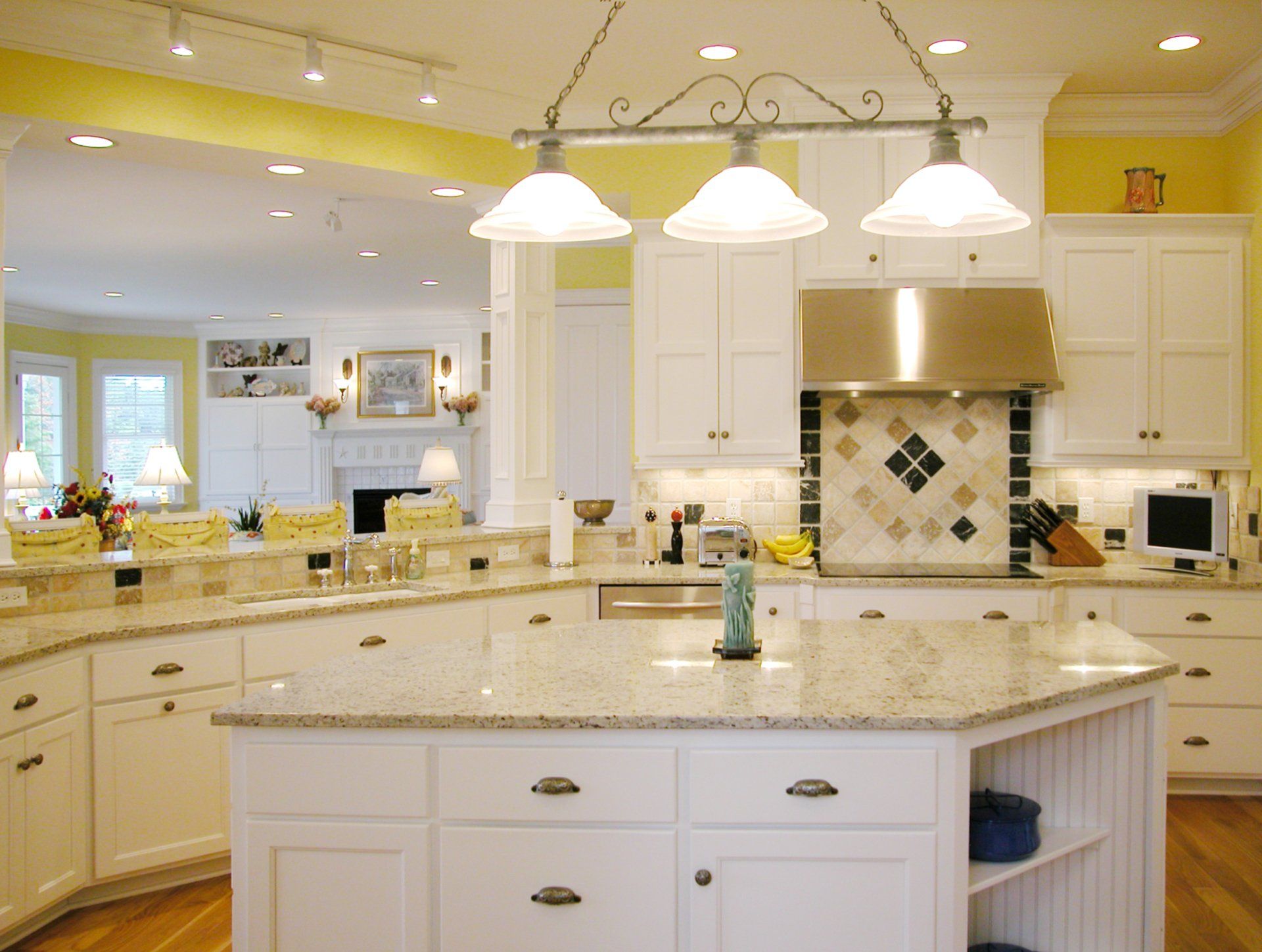 A kitchen with white cabinets and granite counter tops.