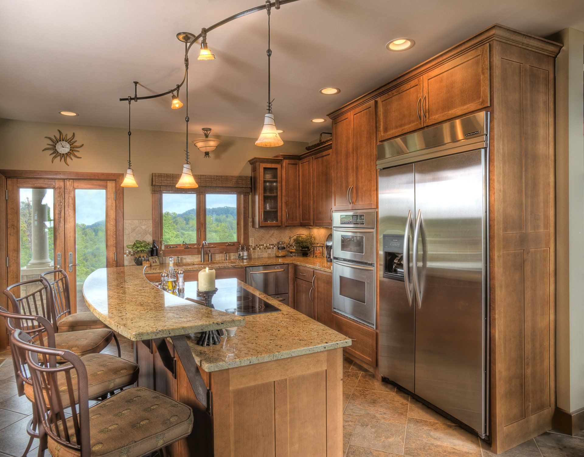 Kitchen with wood cabinets, stainless steel appliances, and granite island with bar stools.