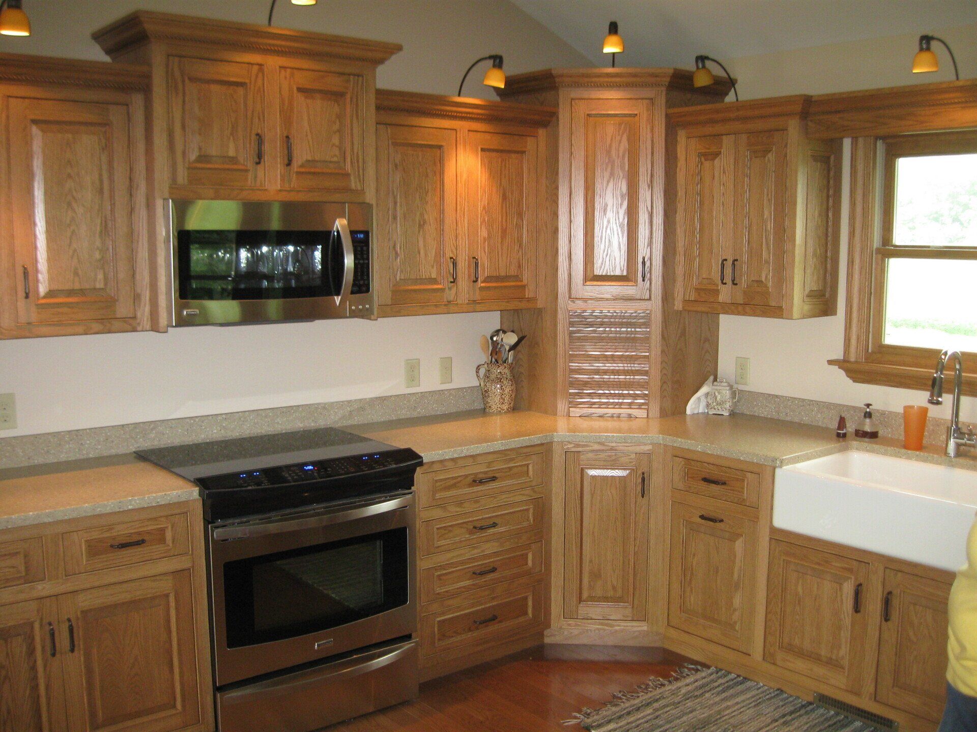 Wooden kitchen cabinets with a stainless steel microwave and stove.