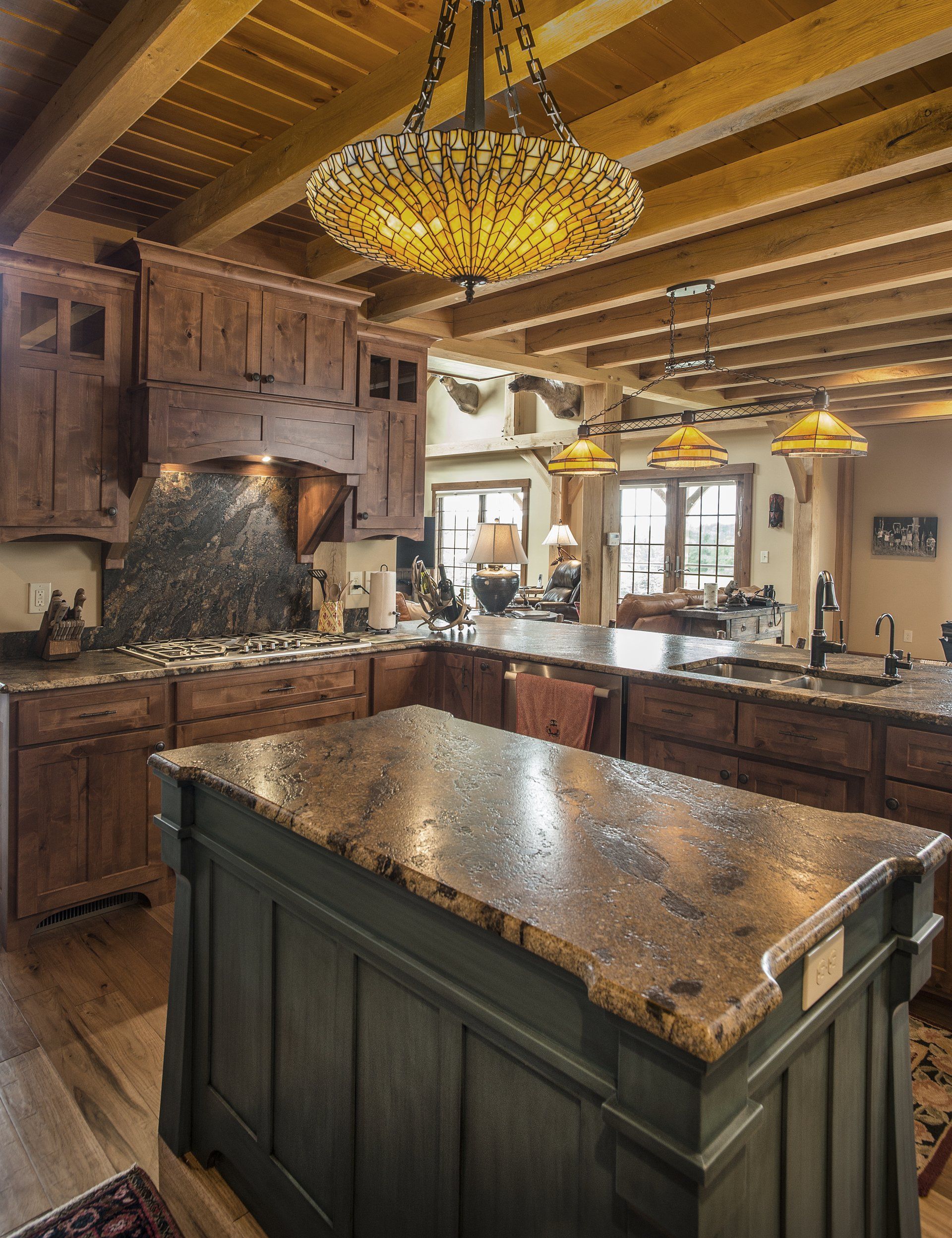 Kitchen with wood cabinets, stone countertops, and a large central island.