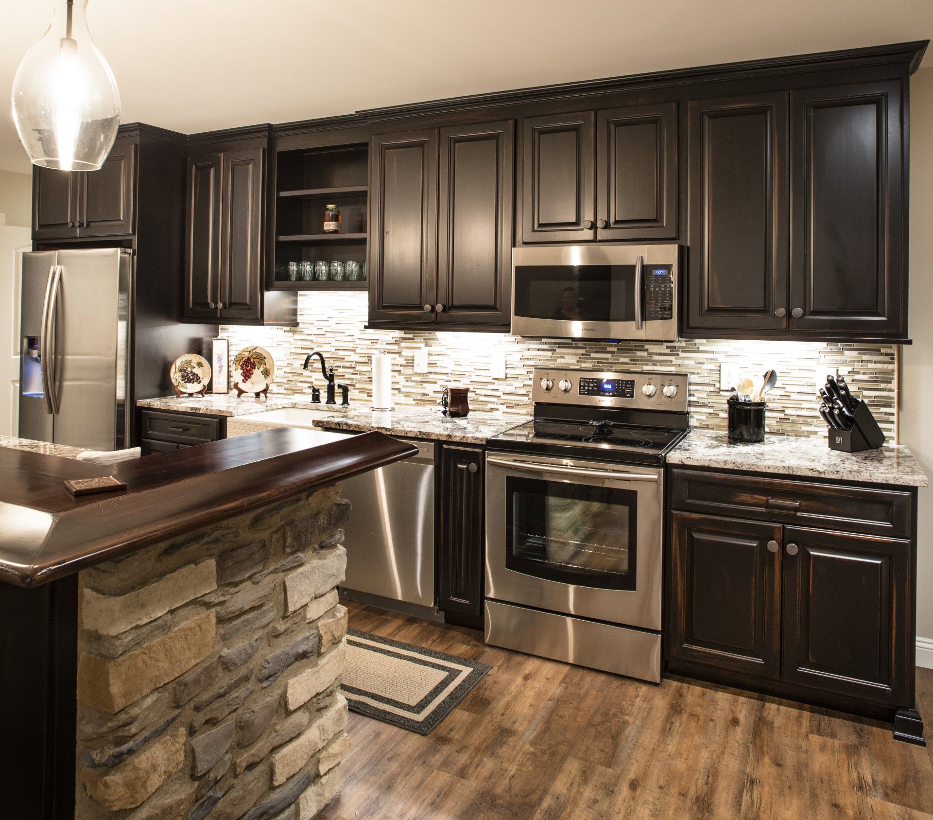 A kitchen with black cabinets and stainless steel appliances.