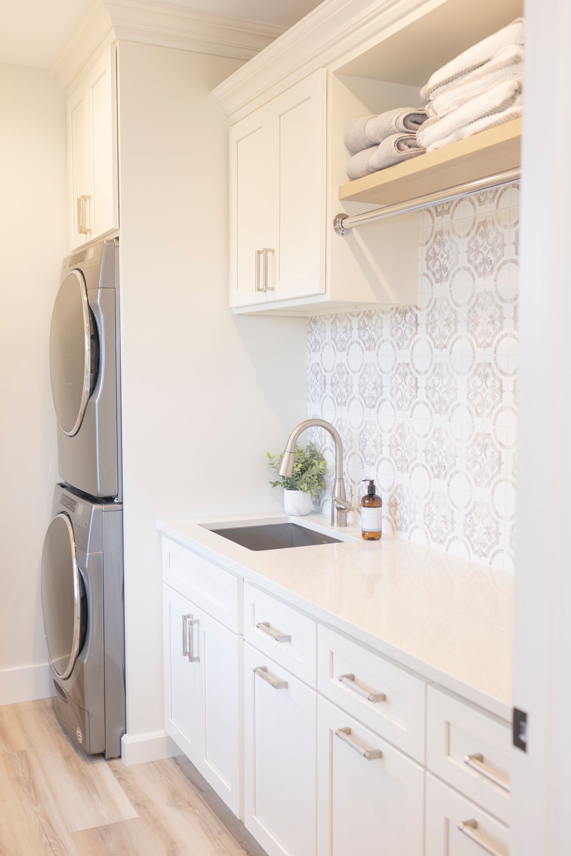 A laundry room with a washer and dryer and a sink.