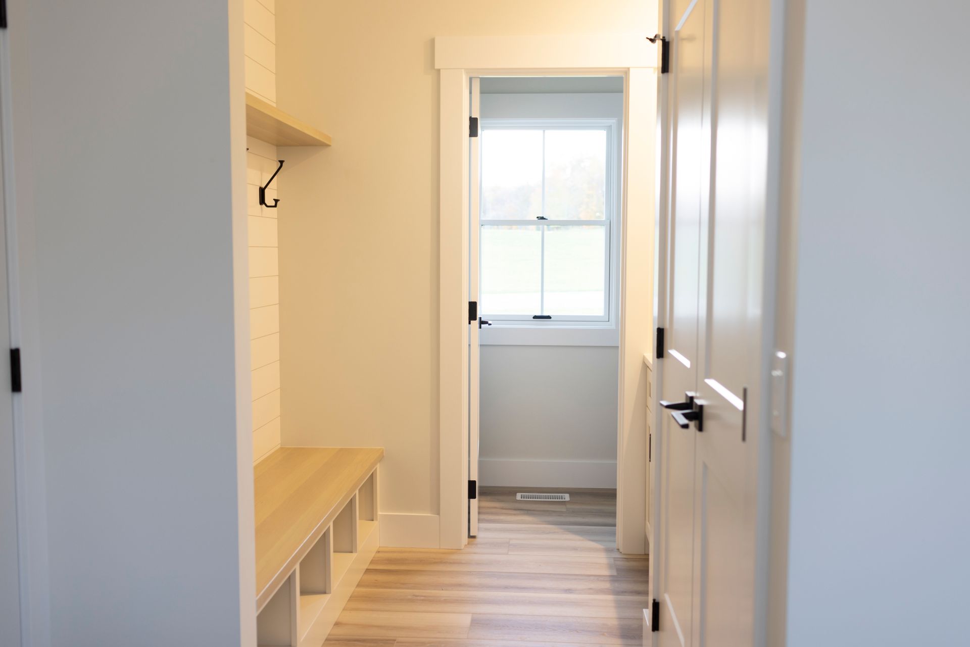A hallway with a bench and a window in a house.
