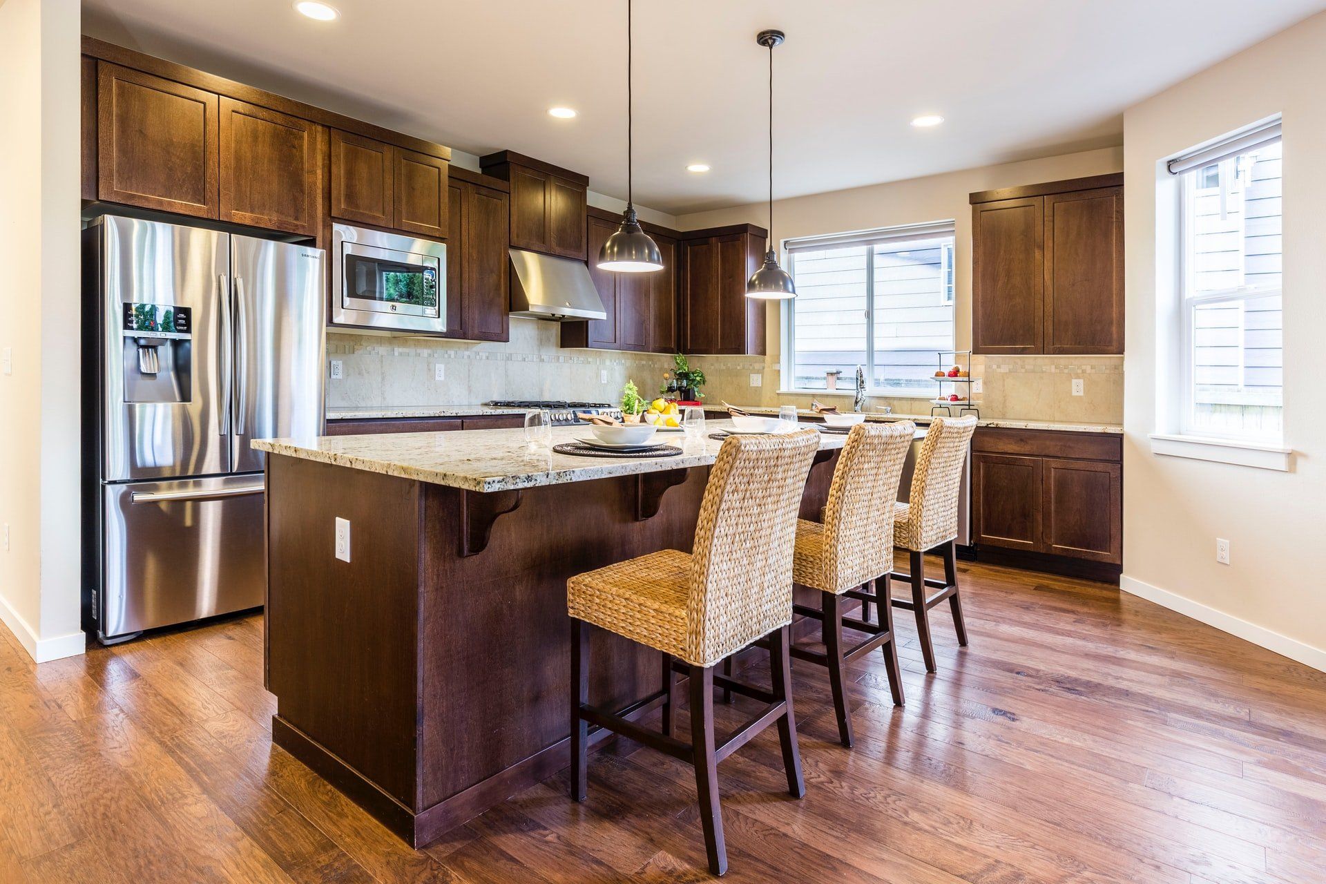 A kitchen with an island, stainless steel appliances, and wooden cabinets.