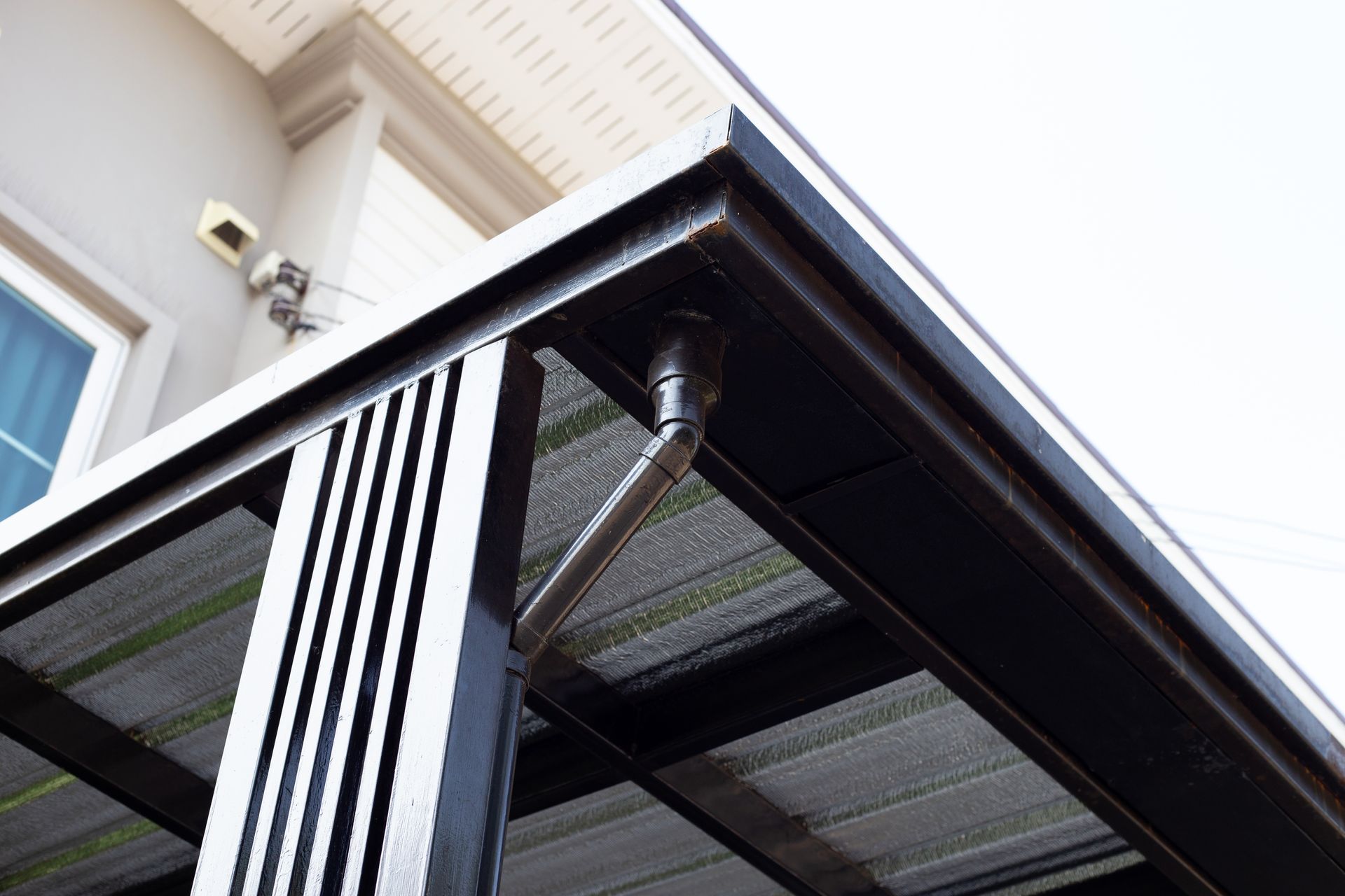 Close-up of a modern black awning with striped curtains under a building eave